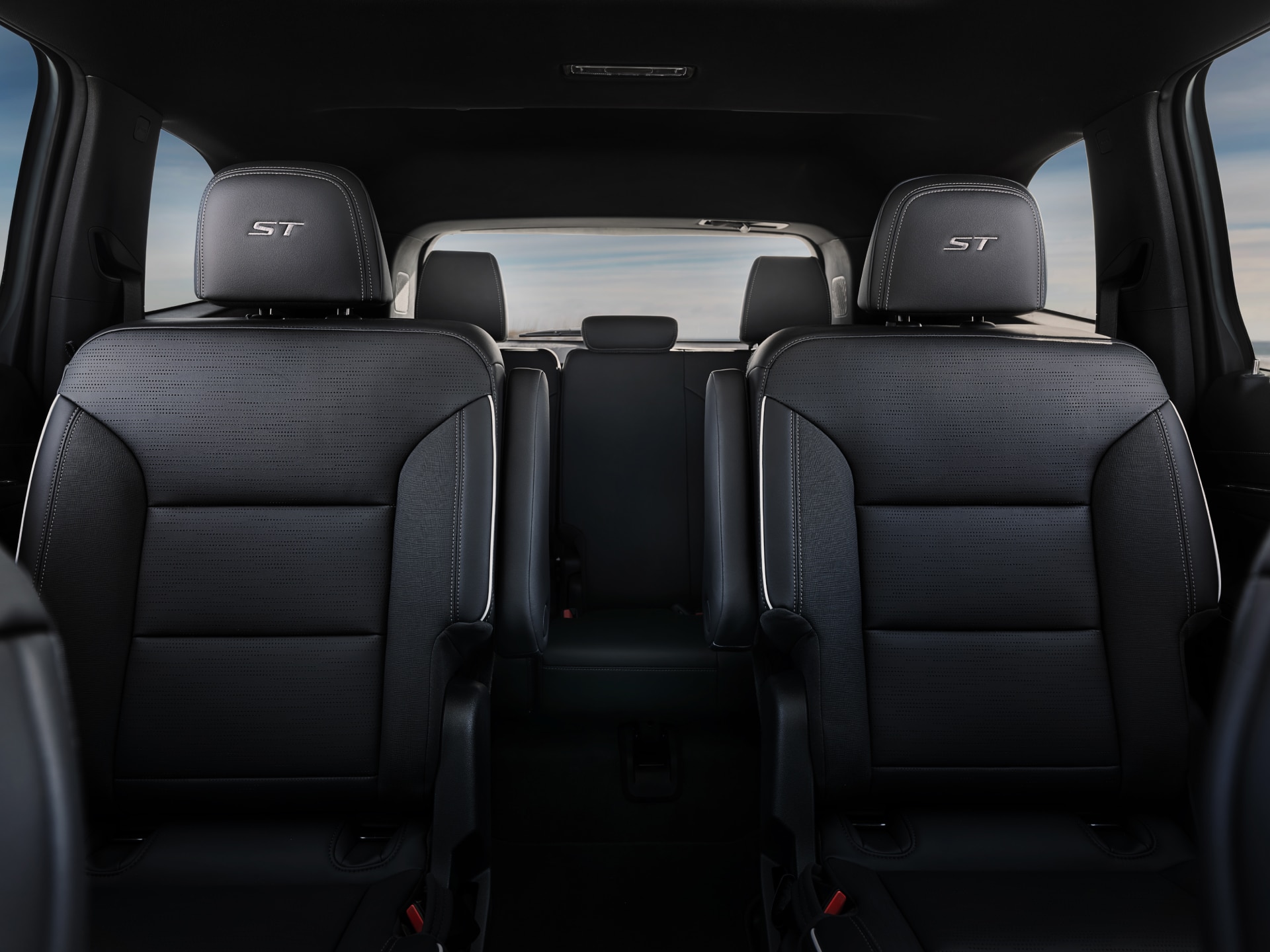 The Interior View of the Rear Passenger Seats of a Buick with Three Rows of Dark Gray Seats