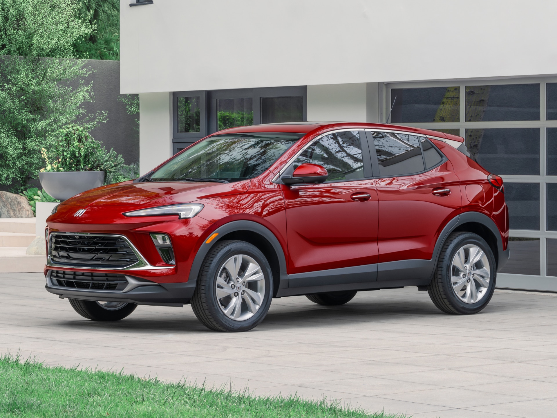 A Red Buick Encore GX Parked in front of a Modern House
