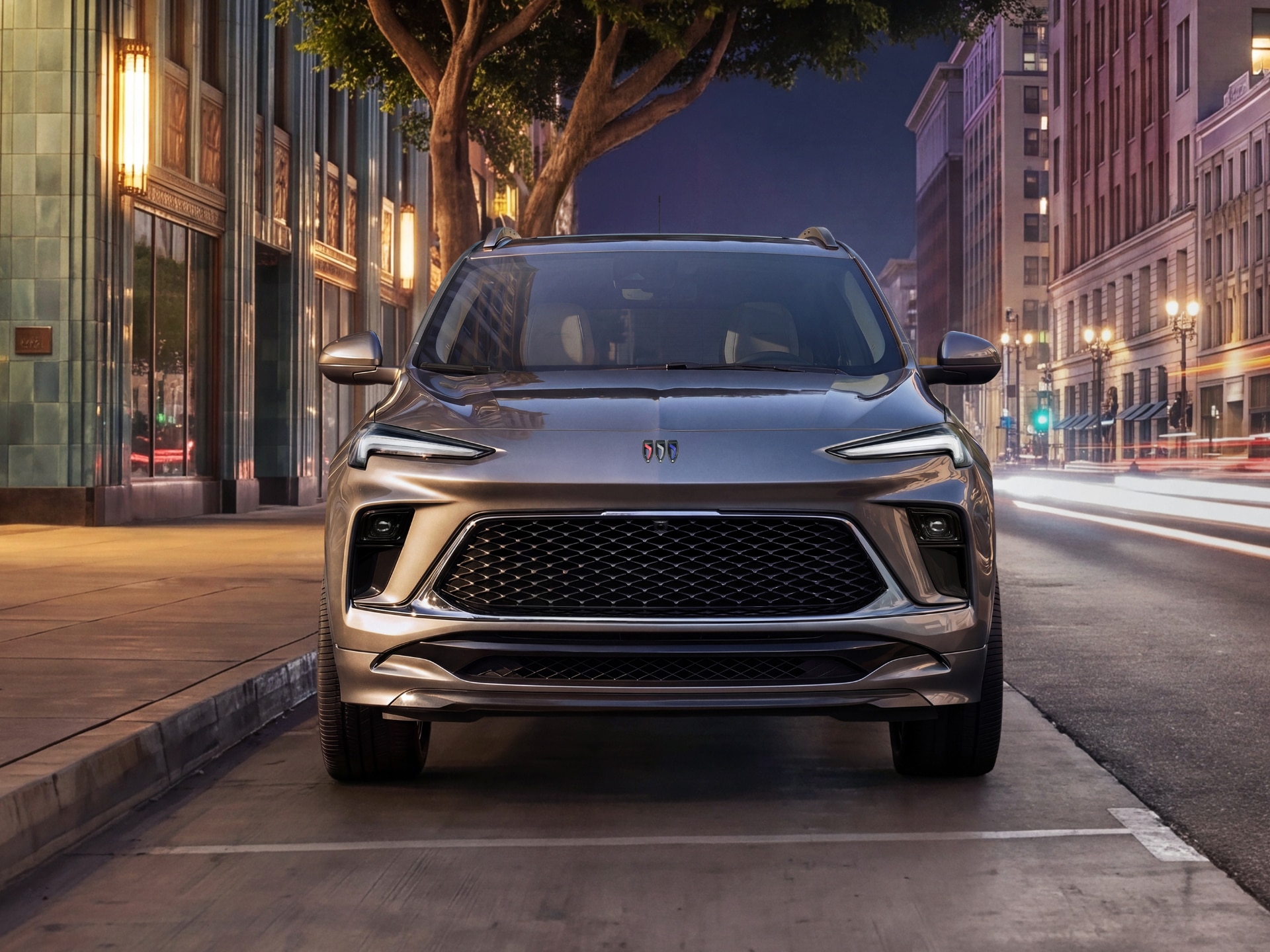 A Gray Buick Encore GX Parked on a City Street at Night with Light Trails
