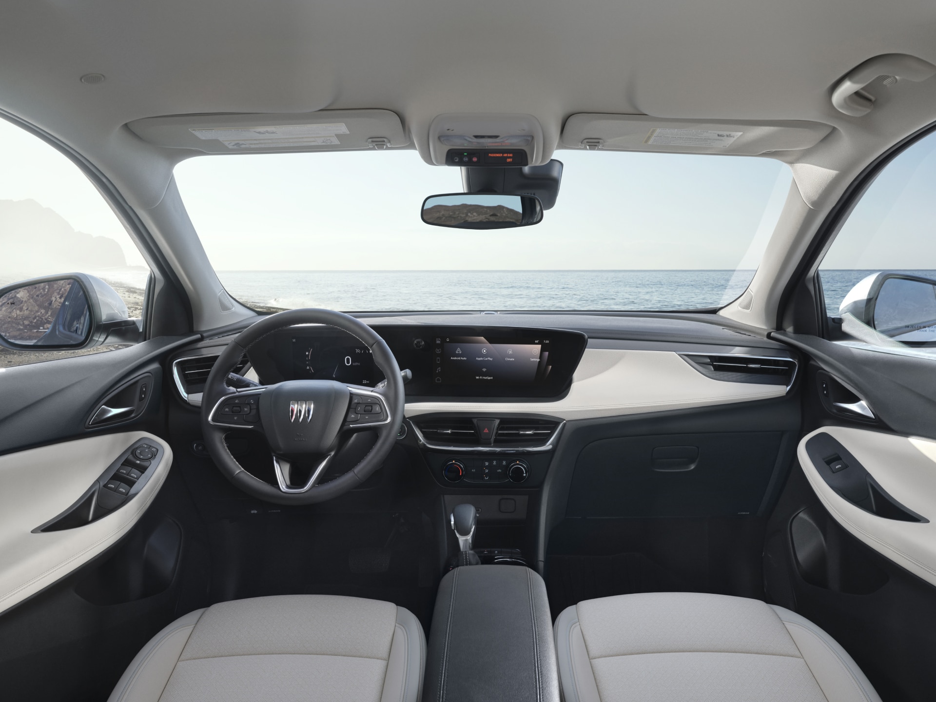Interior View of a Buick Dashboard and Steering Wheel with the Ocean Visible Through the Windshield
