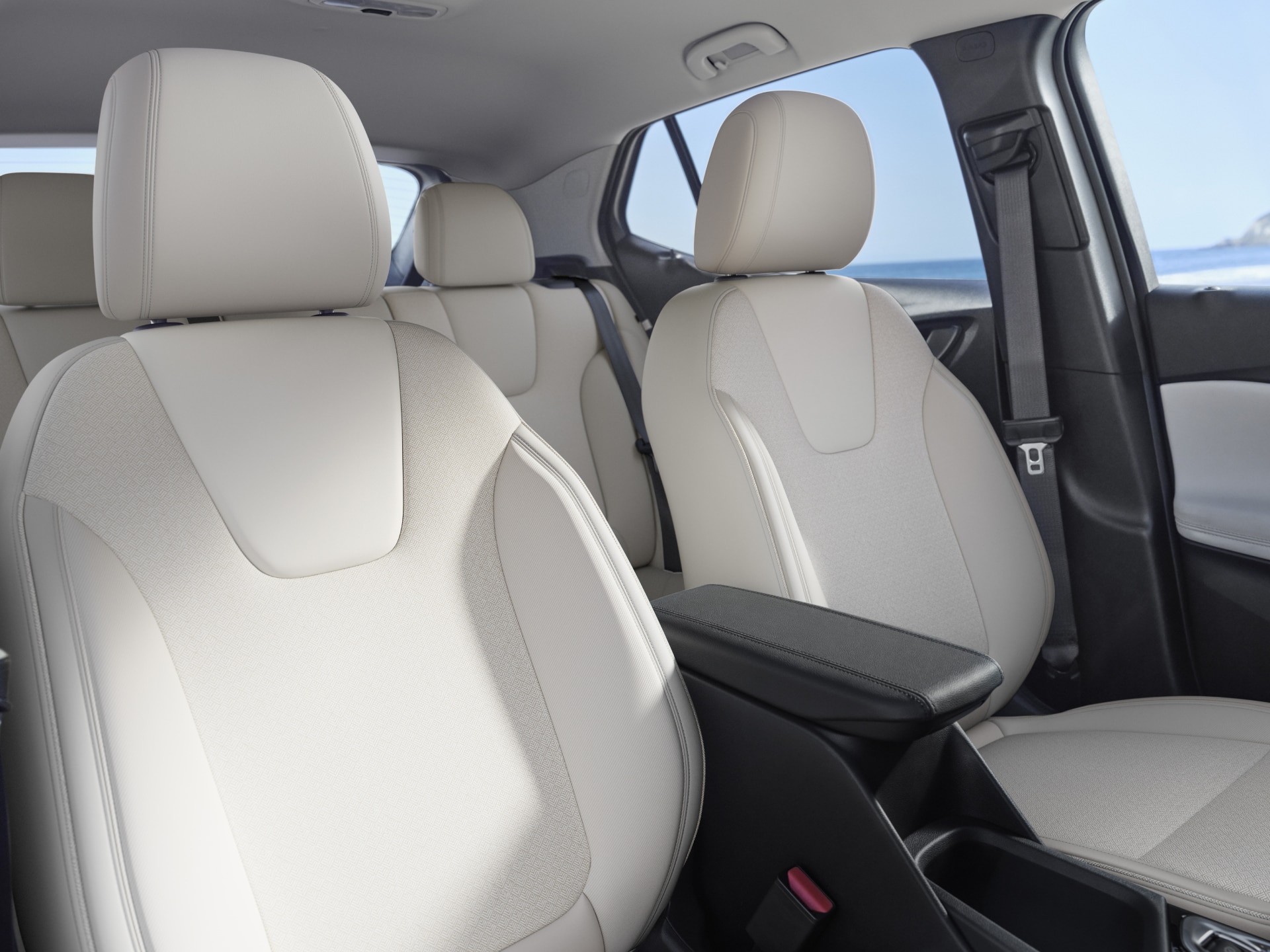 Close-up of Light-Colored, Perforated Leather Front Seats and a Center Console inside a Buick Vehicle