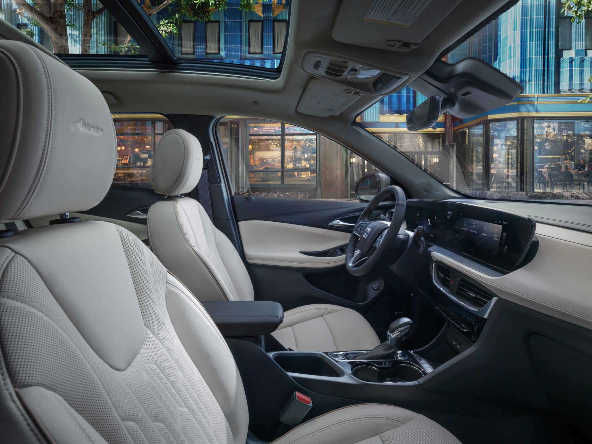 Interior View of a Buick Vehicle with Light-Colored Seats and Dashboard, Parked on a City Street with Stores Visible