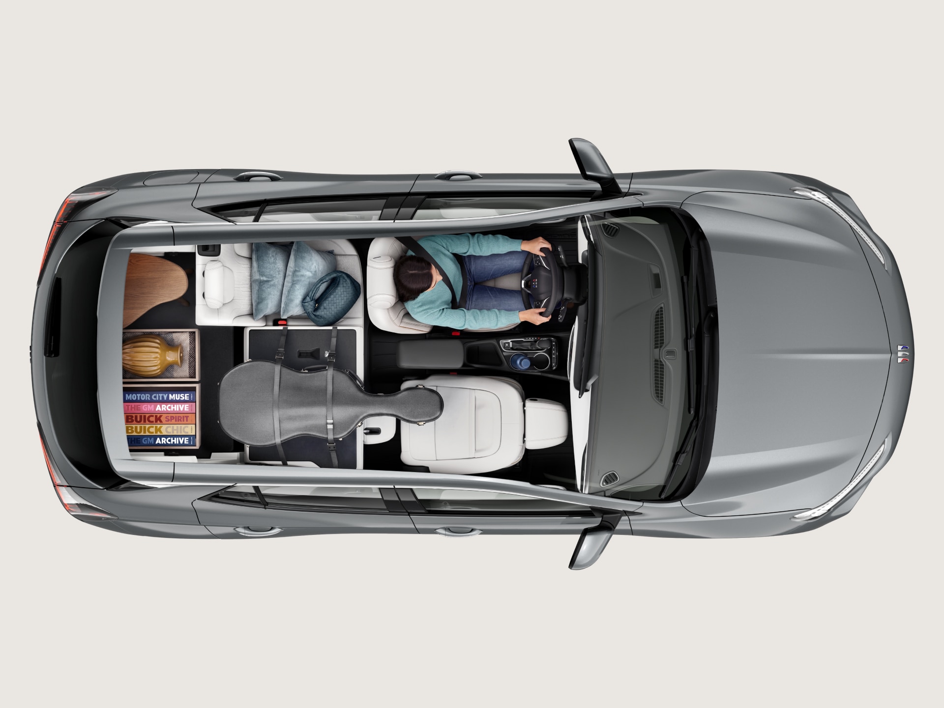 Overhead View of a Gray Buick SUV Interior Showing a Driver, Passenger Seat, and Items in the Cargo Area like a Guitar Case and Boxes