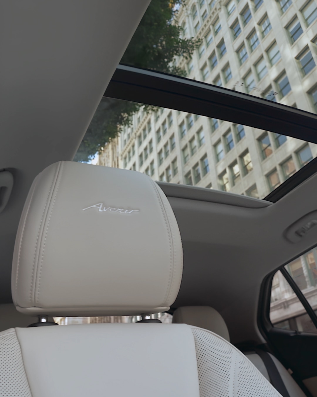 The Interior View of a Buick Encore GX Showing Cream-Colored Seats and an Open Sunroof