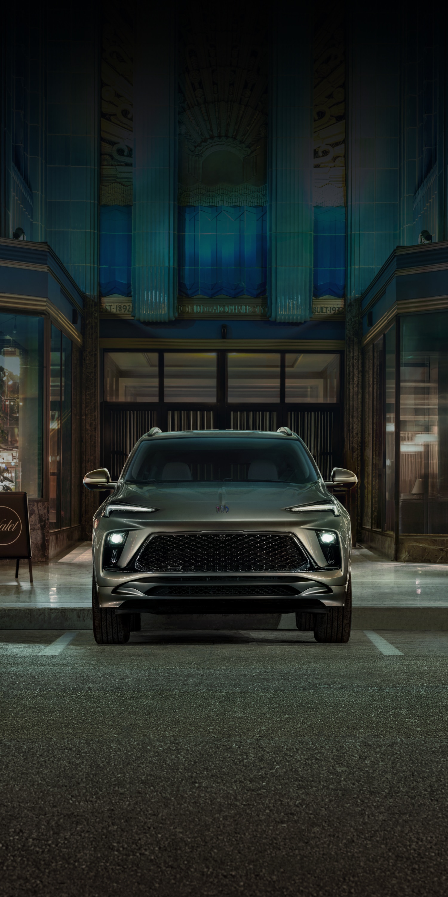 A Gray Buick Encore GX Parked in front of a Grand Building at Night