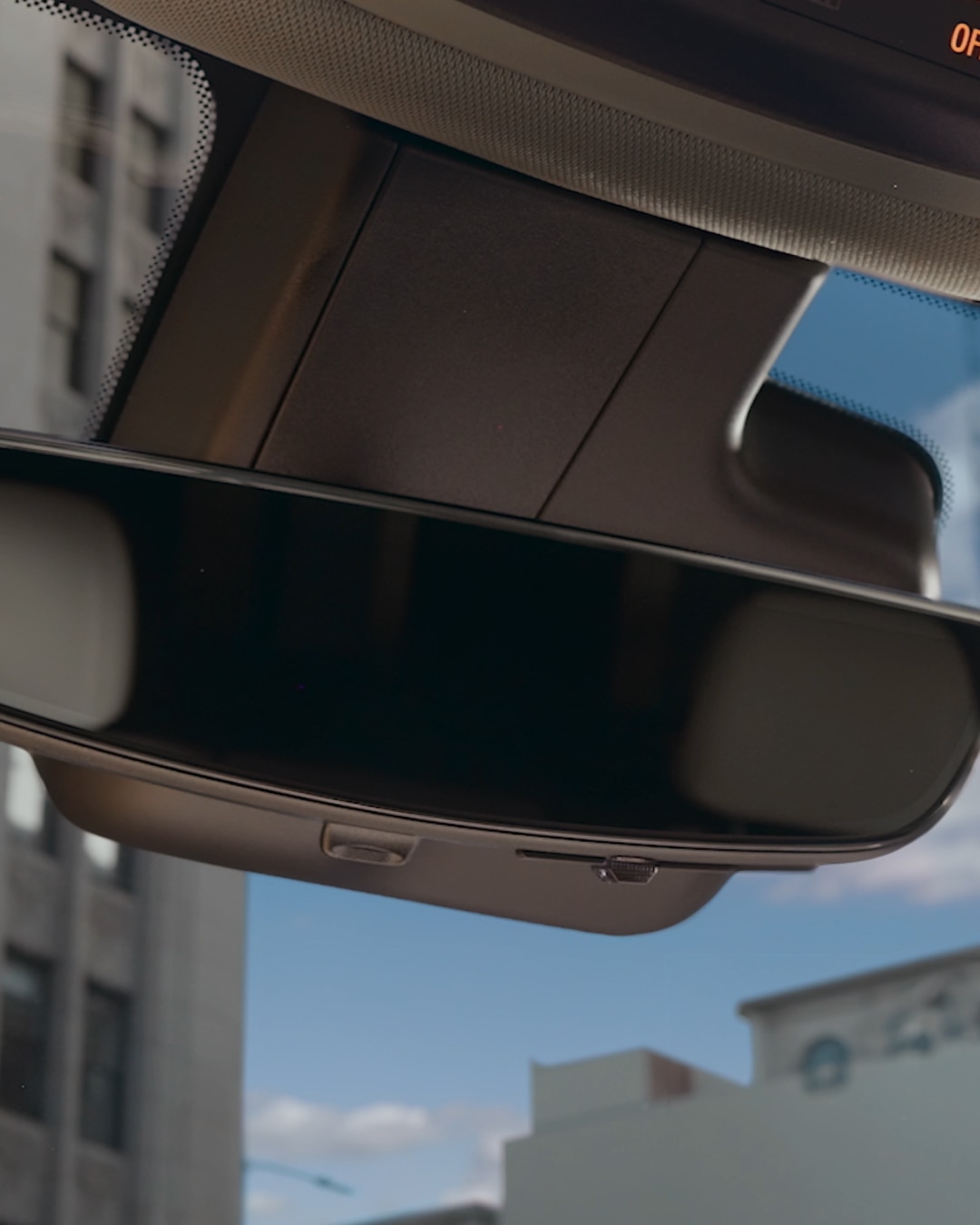 Car Interior Rearview Mirror Showing City Buildings Reflected and a Disclaimer at the Bottom