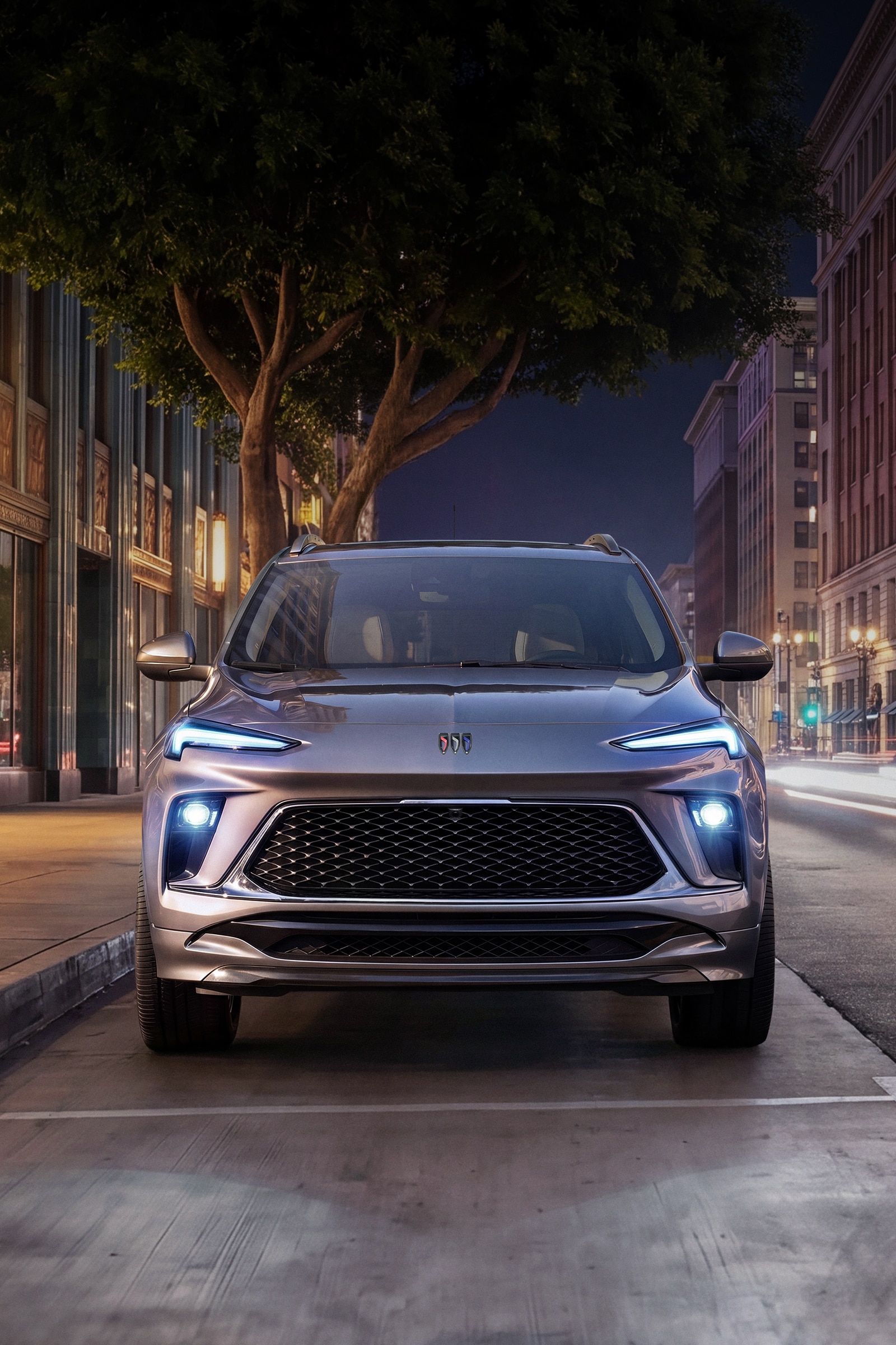 A Gray Buick Encore GX Parked on a City Street at Night with Light Trails