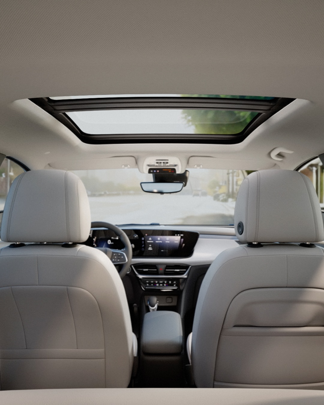 View of a Buick Vehicle's Interior From the Back Seats Looking Forward, Featuring an Open Sunroof and Dashboard
