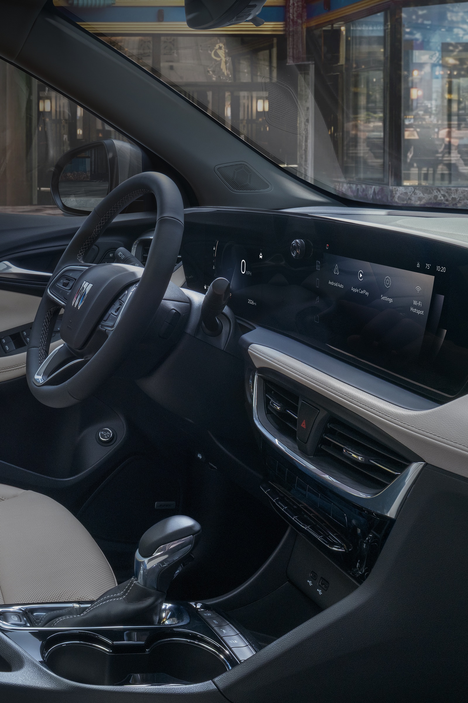 The Interior of a Buick Vehicle Featuring Its Digital Display and the Steering Wheel with the Buick Logo