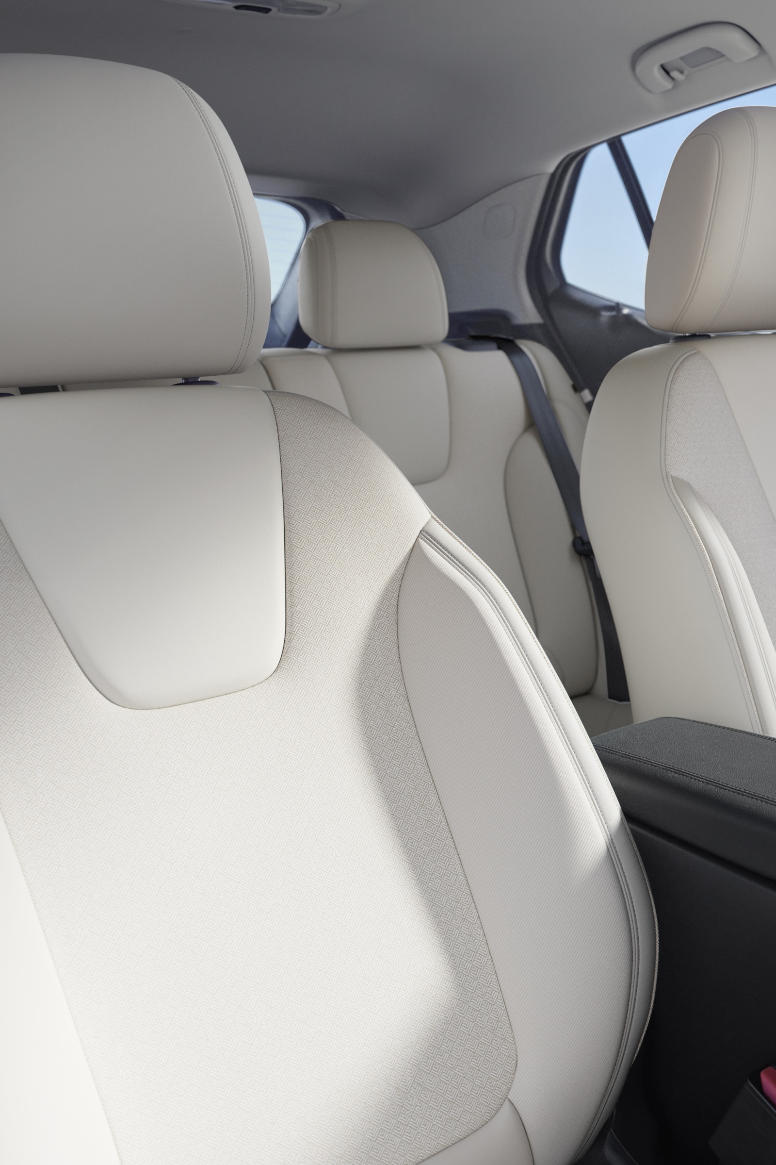 The Interior of a Buick Vehicle with Light-Colored Seats and an Armrest with the Ocean in the Background