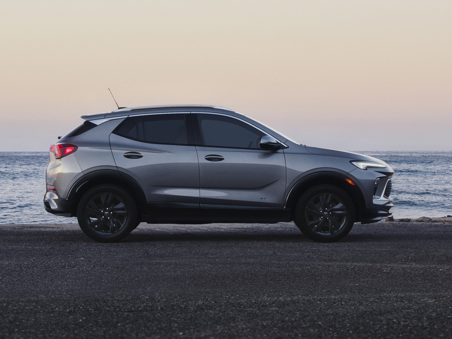 A Gray Buick Encore GX Parked by the Ocean at Sunset