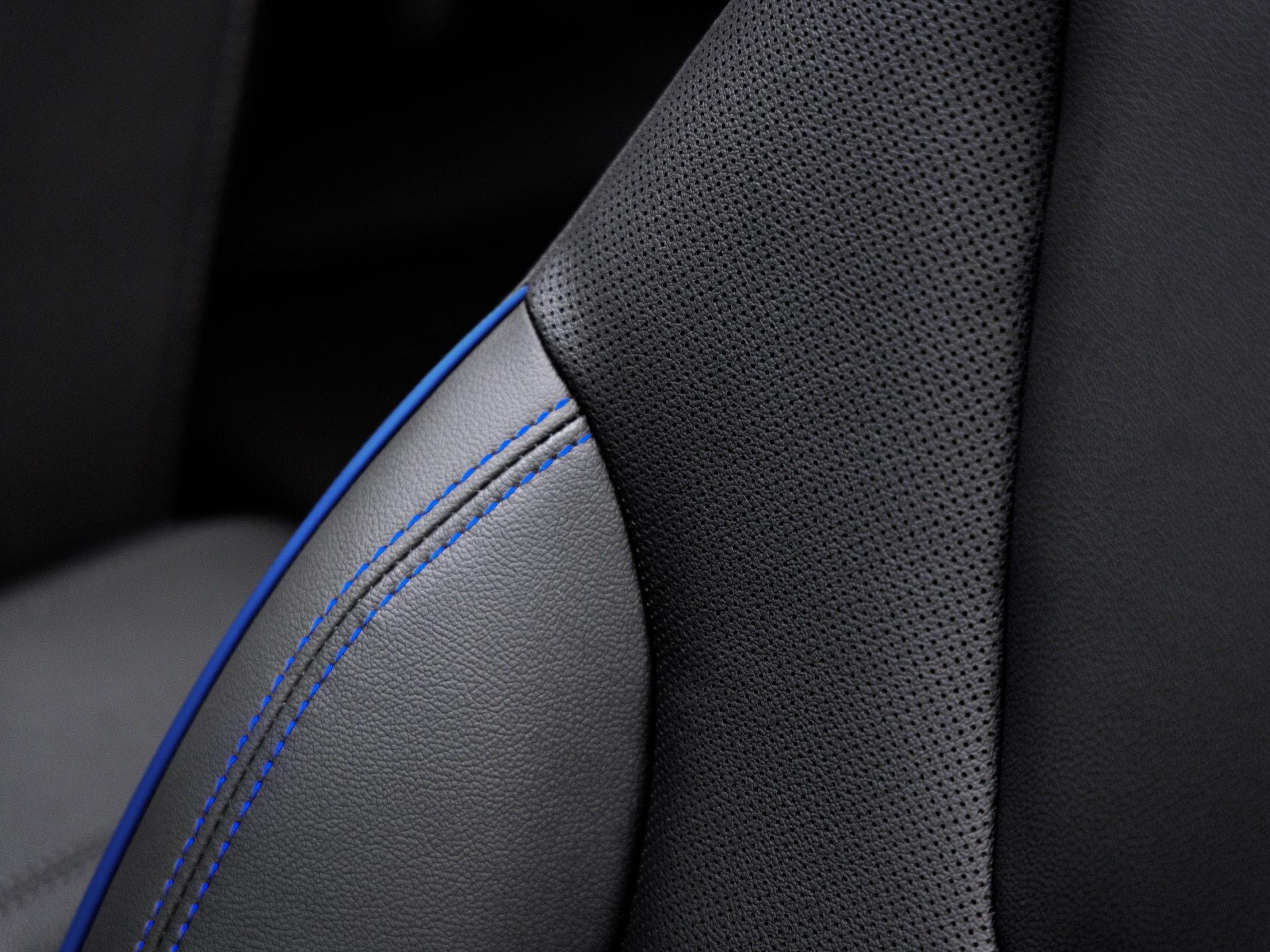 Close-Up of a Black Perforated Leather Car Seat with Blue Accent Stitching