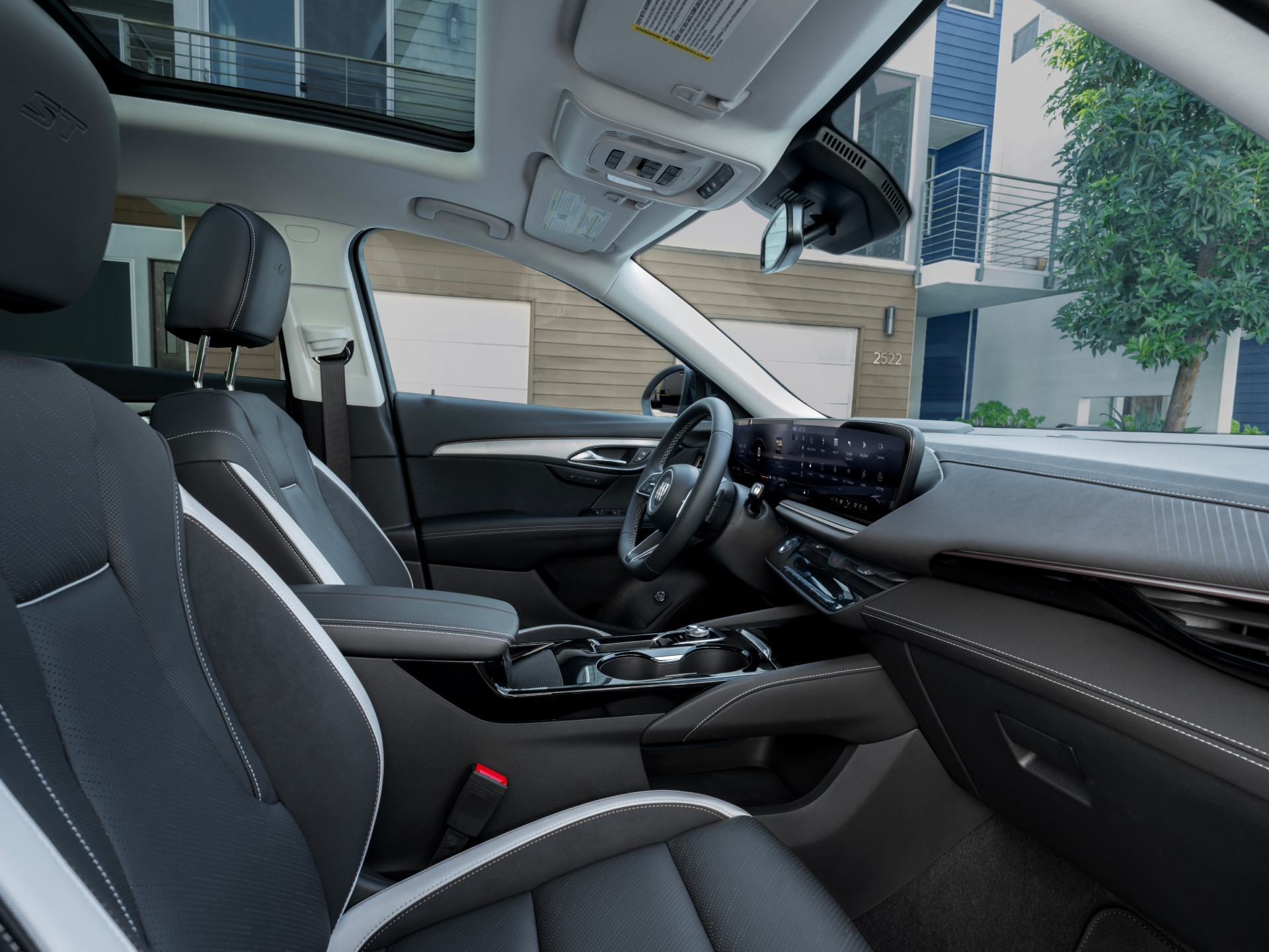 Interior Side View of the 2027 Buick Envision Showing the Dashboard, Steering Wheel, and Front Seats with Black and White Trim