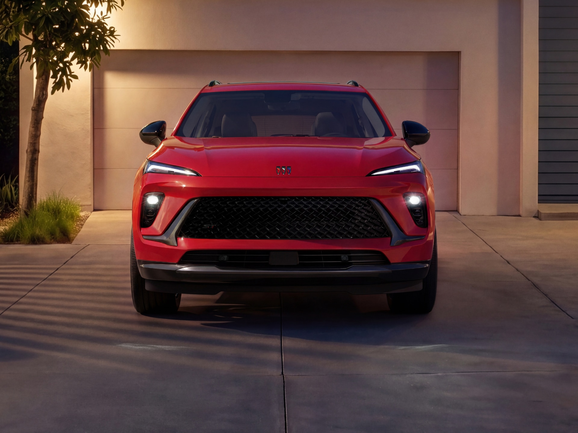 A Red Buick SUV Front View Parked in Front of a White Garage Door at Night