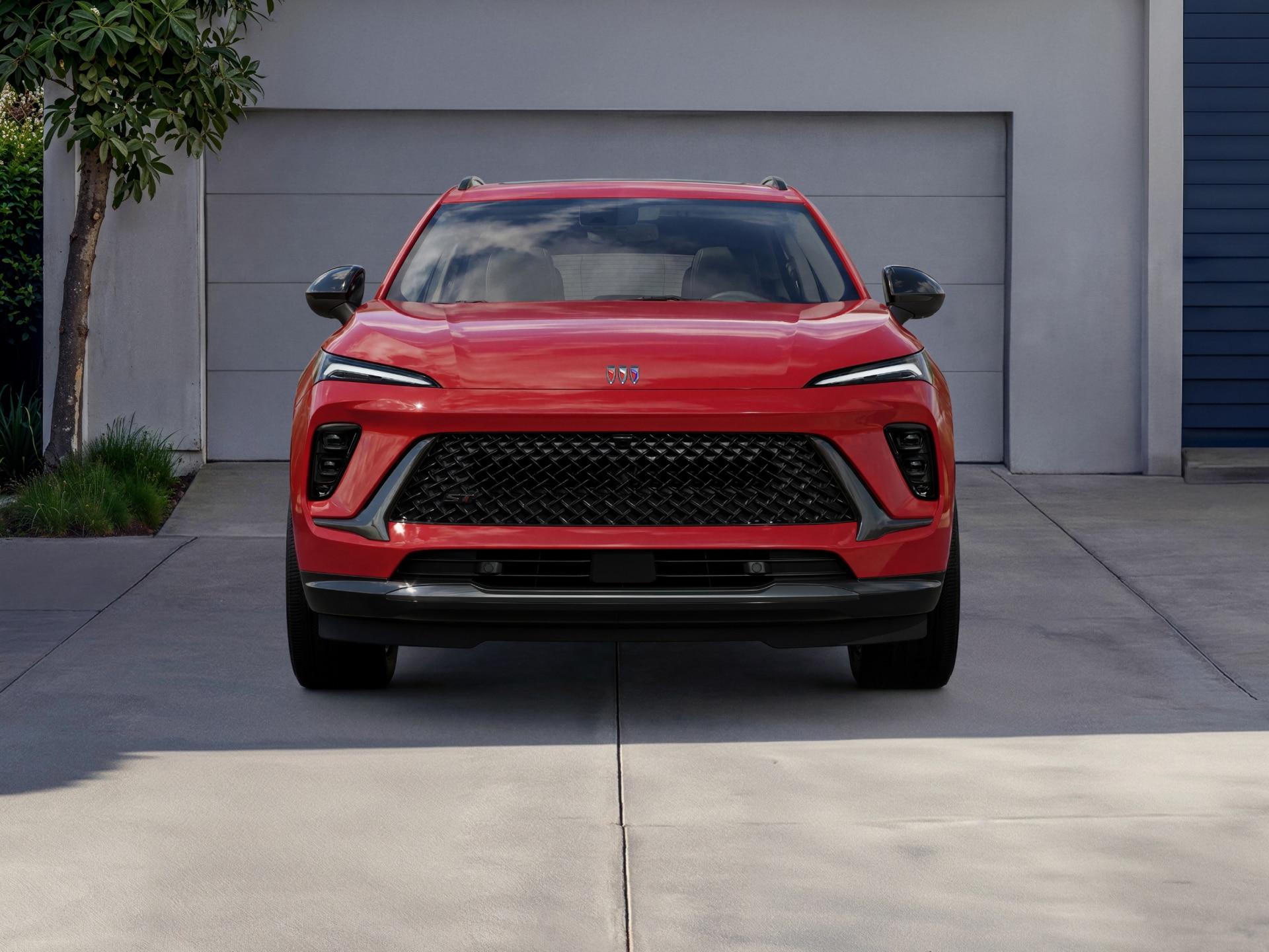A Red Buick SUV Front View Parked in Front of a White Garage Door