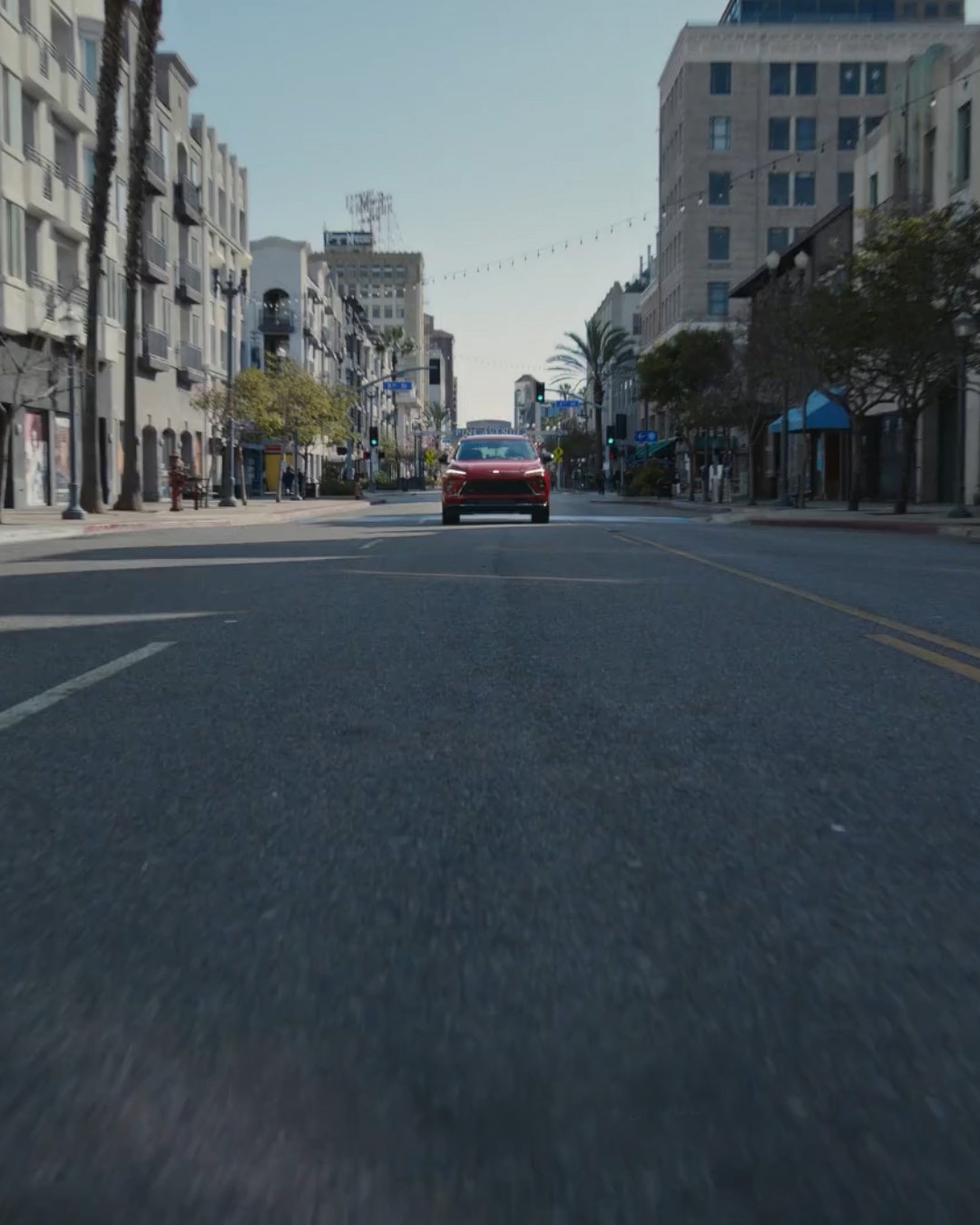 A Red Buick Envision SUV Driving on a City Street with Buildings