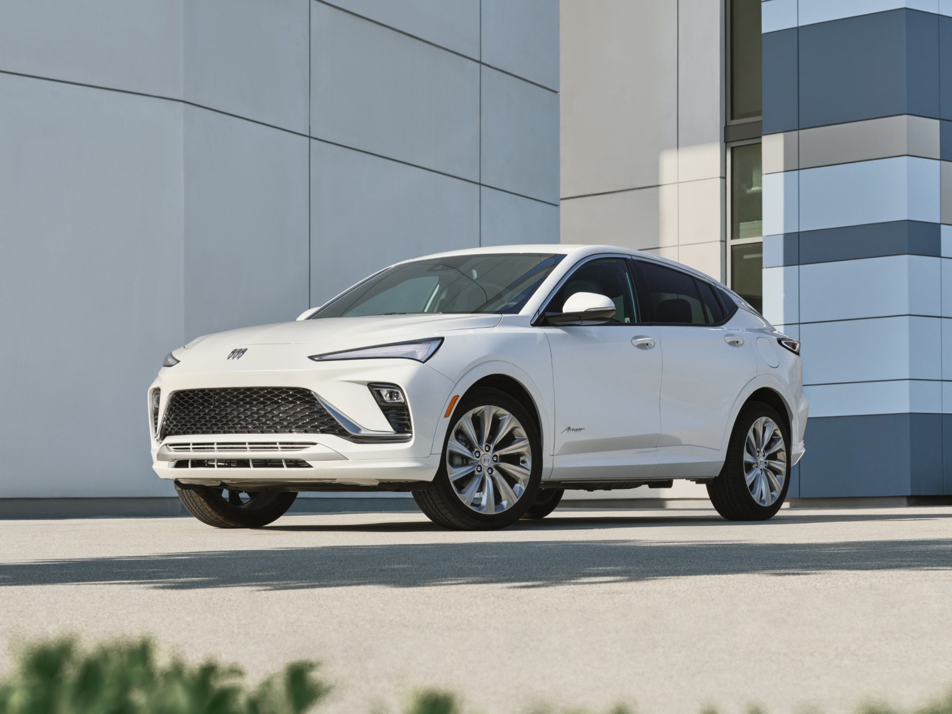 A White Buick Envista Avenir Parked in Front of a Modern Building with Architectural Details