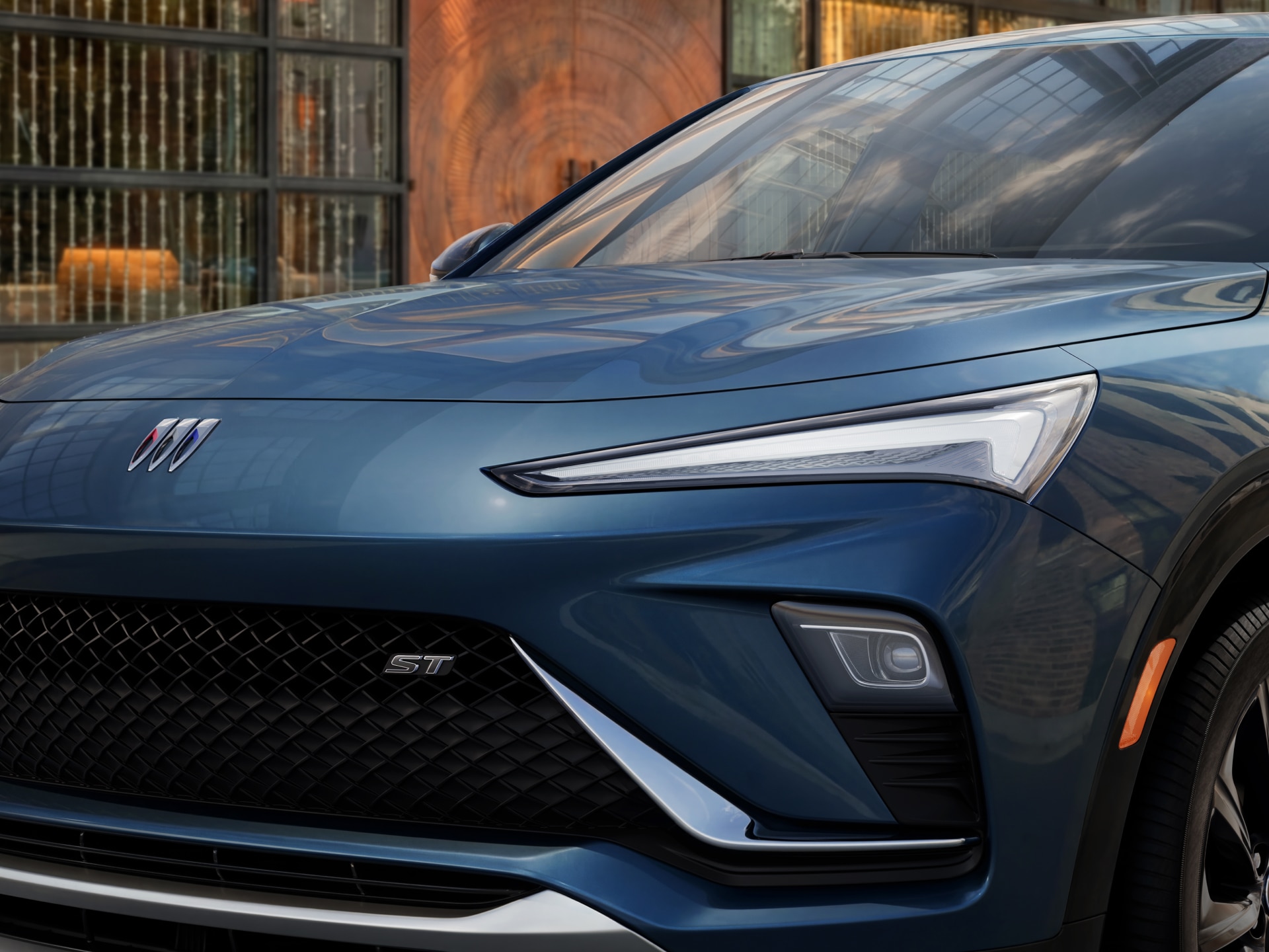 A Close-Up View of the Front Grille and Headlight of a Blue Buick Envista ST with the Buick Tri-Shield Logo