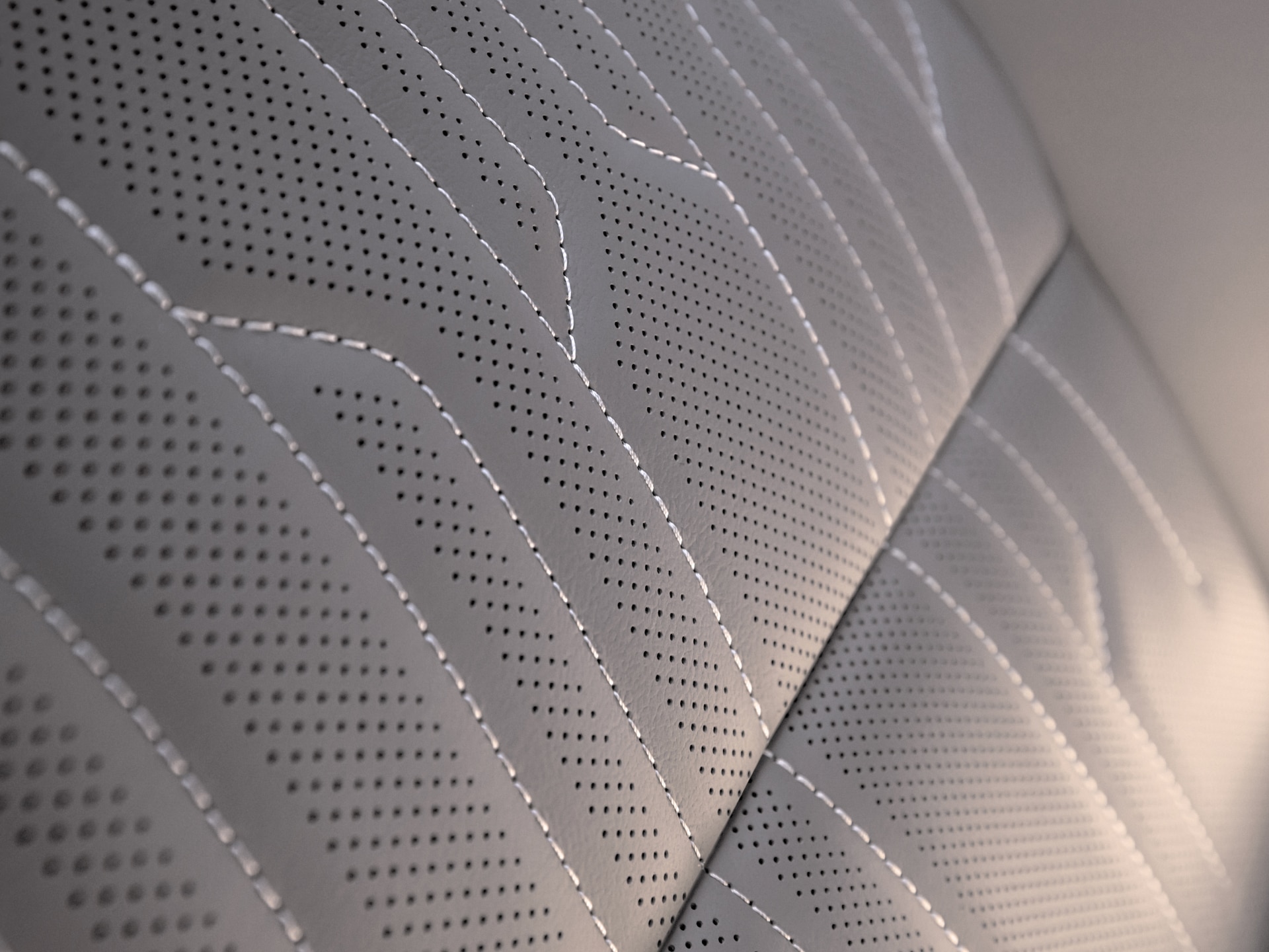 Detailed View of Perforated Light Gray Buick Leather Car Seat Upholstery with White Stitching