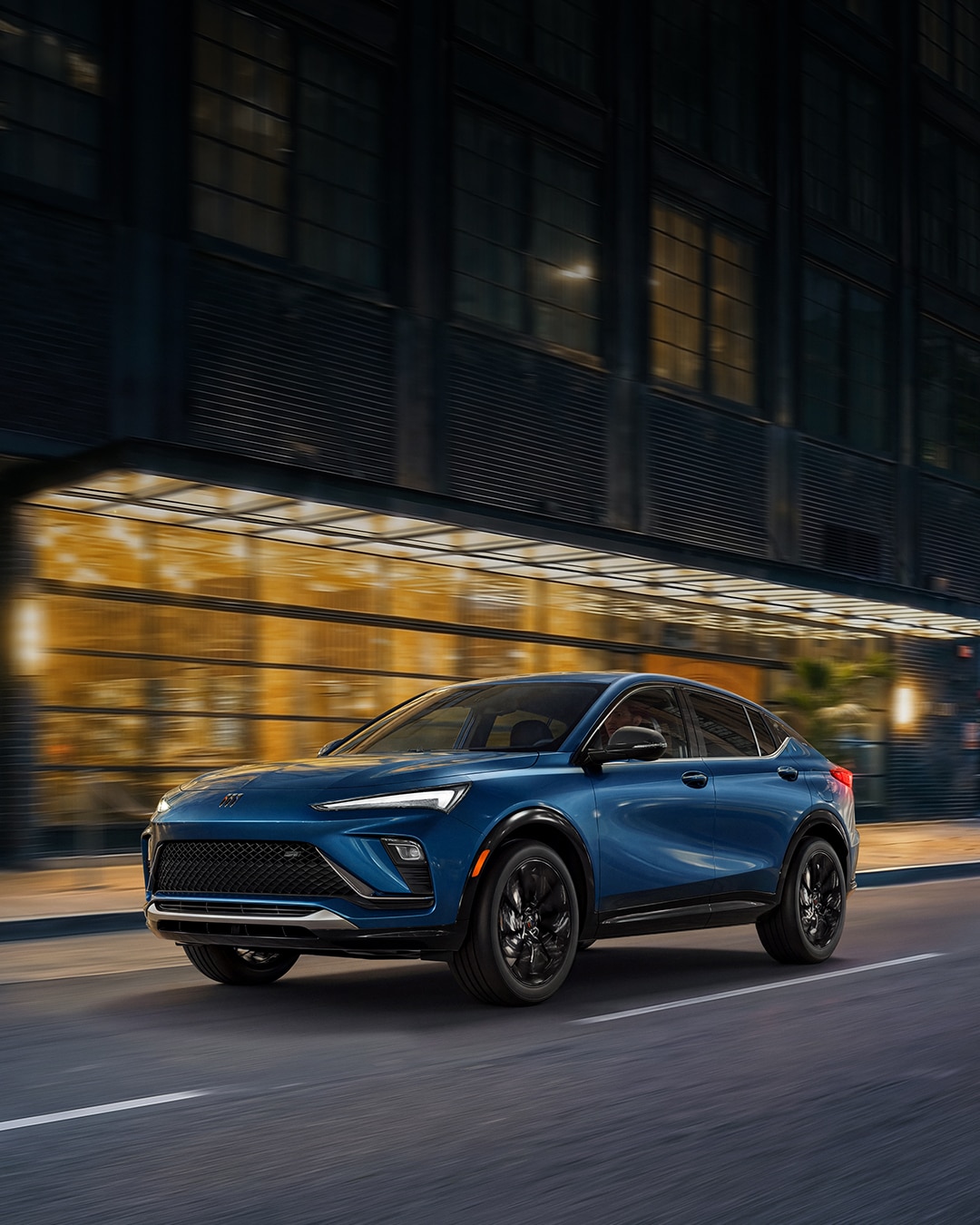 A Blue Buick Envista SUV Parked on a City Street at Night