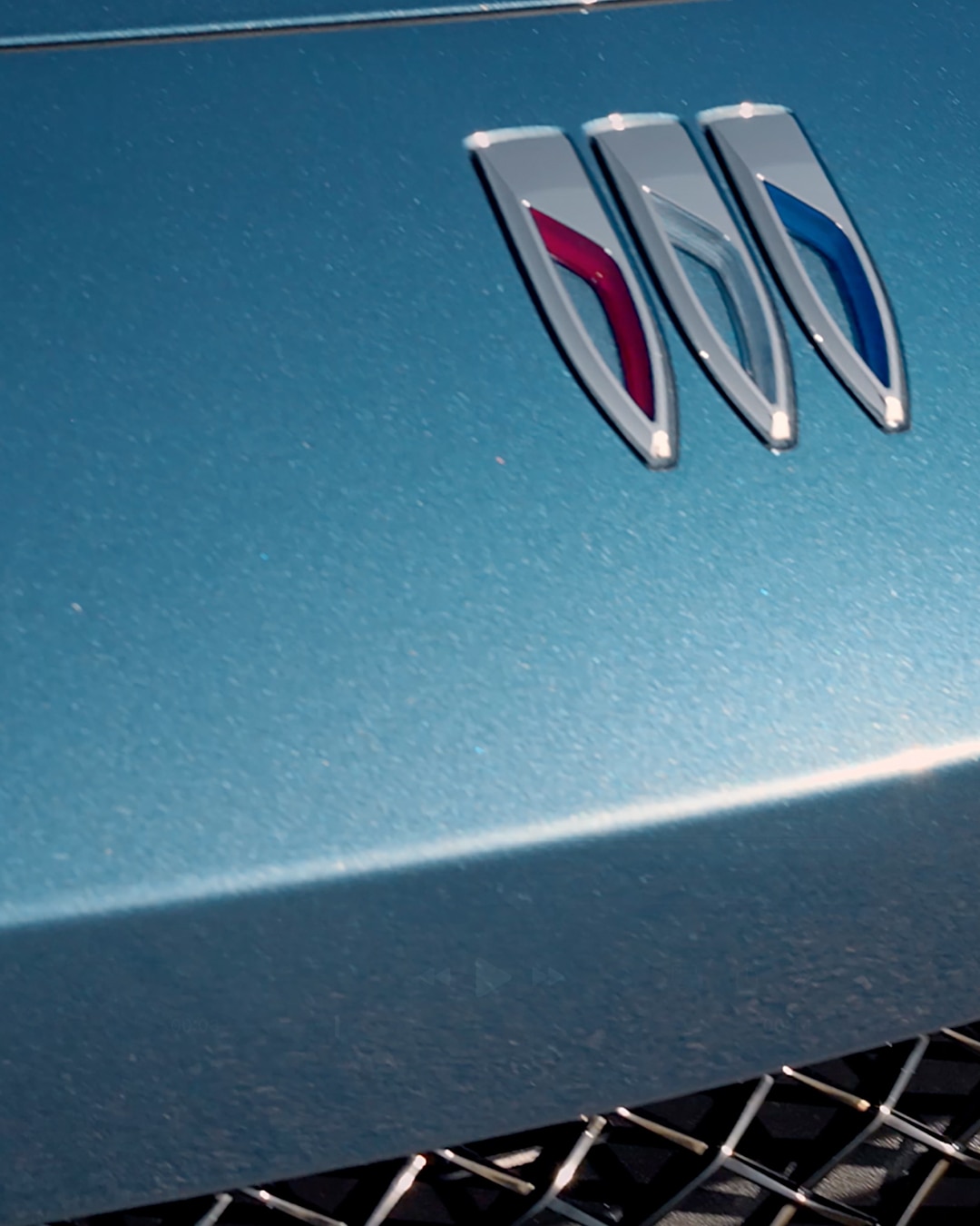 A Close-Up View of the Blue Hood and Headlight Detail of a Buick Envista