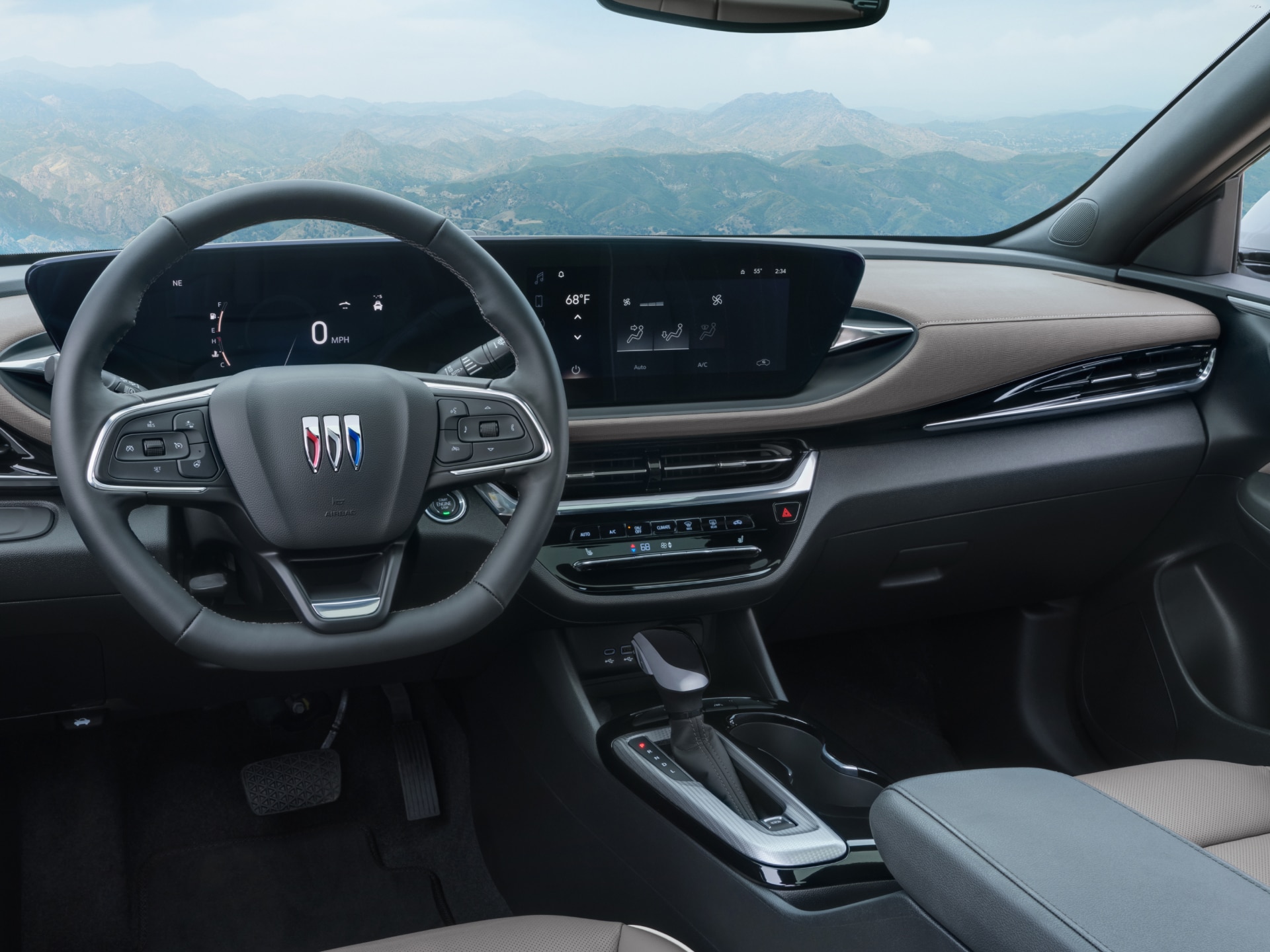 The Interior View of a Buick Dashboard with Steering Wheel and Screens Overlooking Mountains