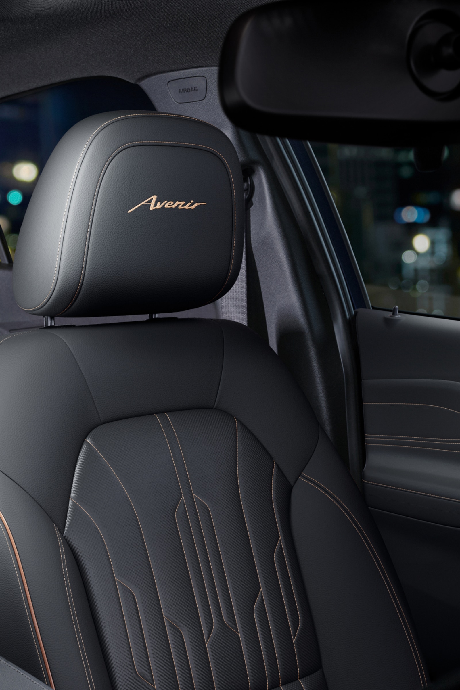 A Close-up of the Front Passenger Seat of a Buick Avenir with Dark Leather and Copper Stitching