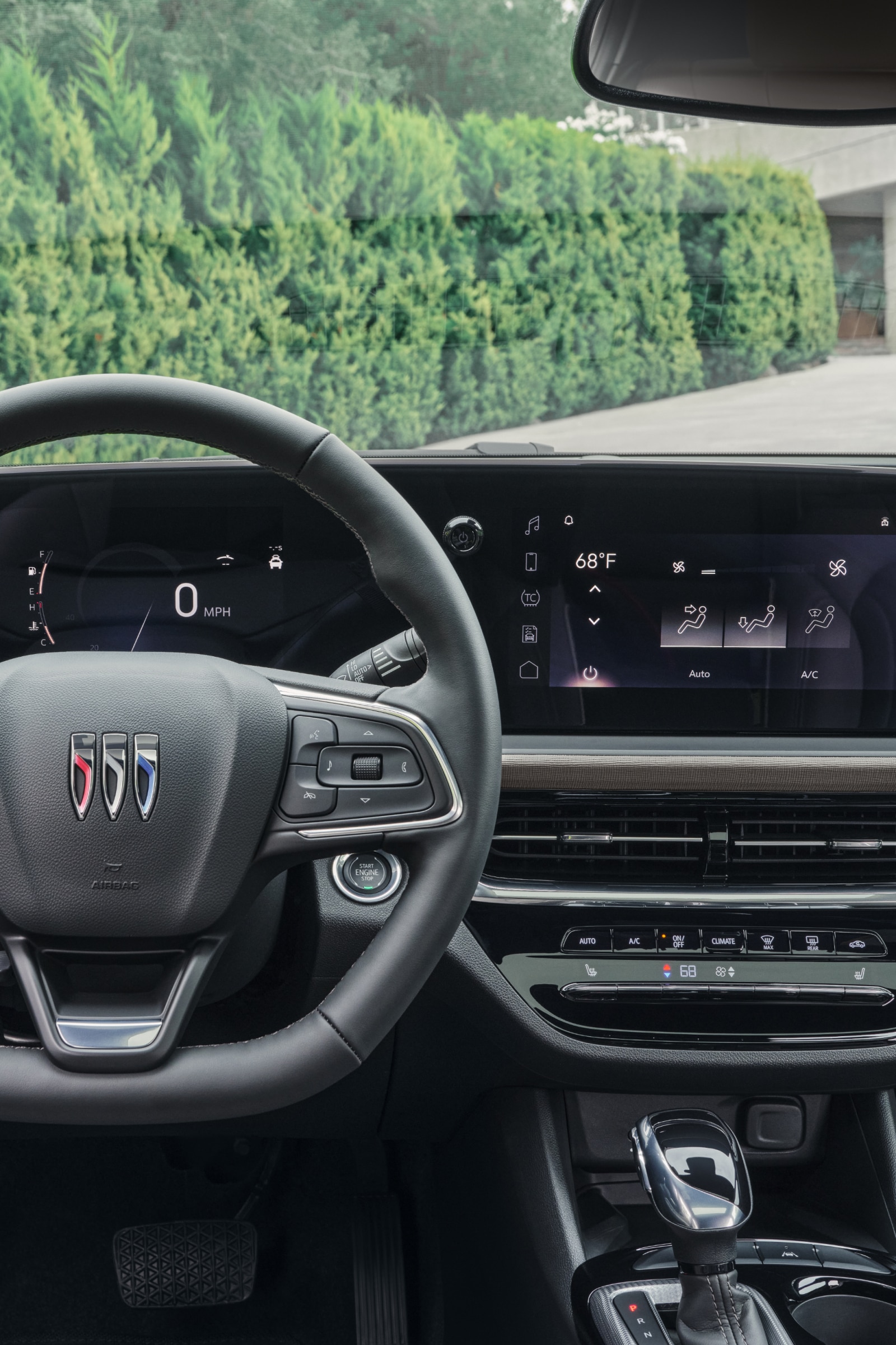 The Interior Dashboard of a Buick Car with a Steering Wheel and Digital Displays