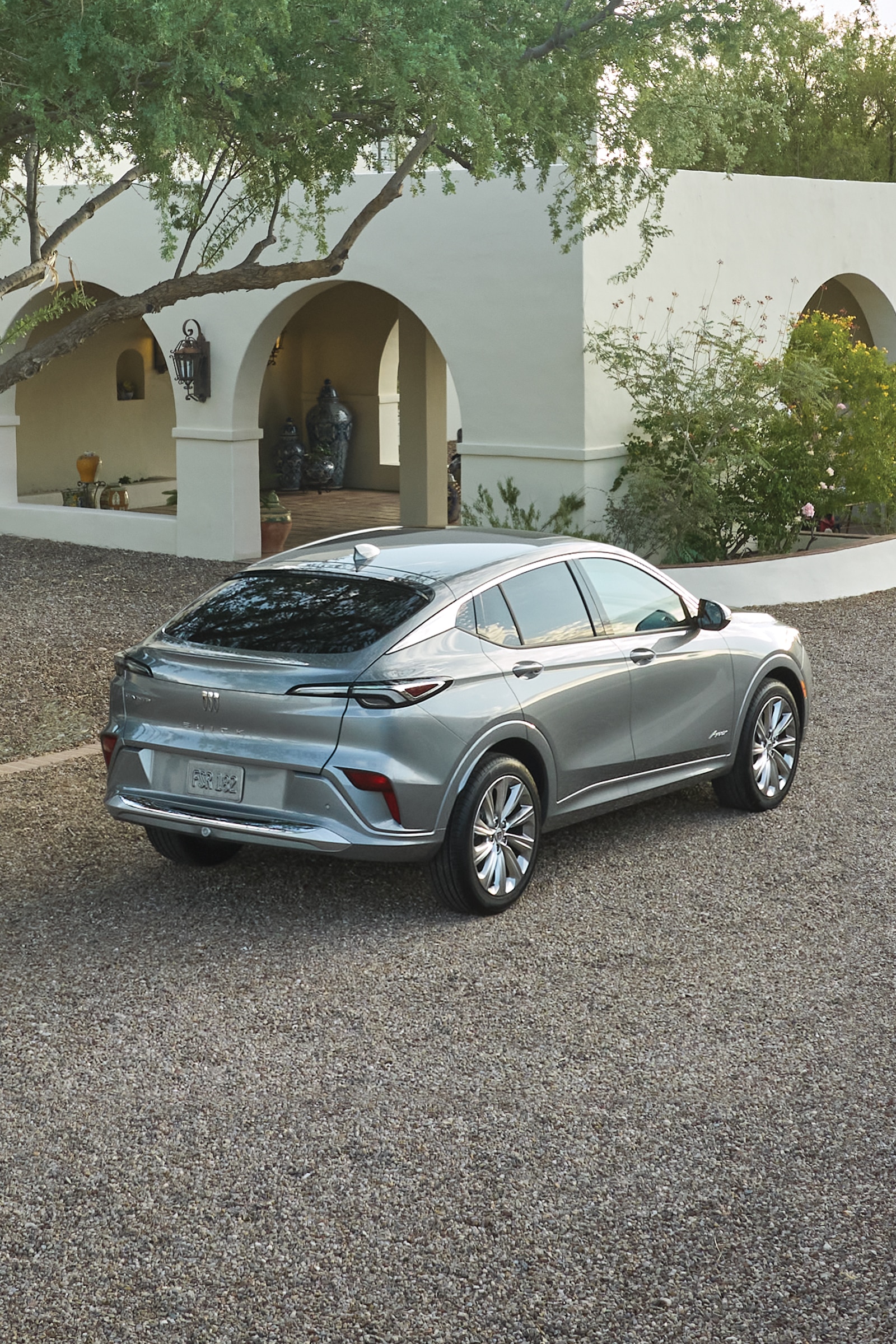 A Rear View of a Gray Buick Envista Parked on a Gravel Driveway