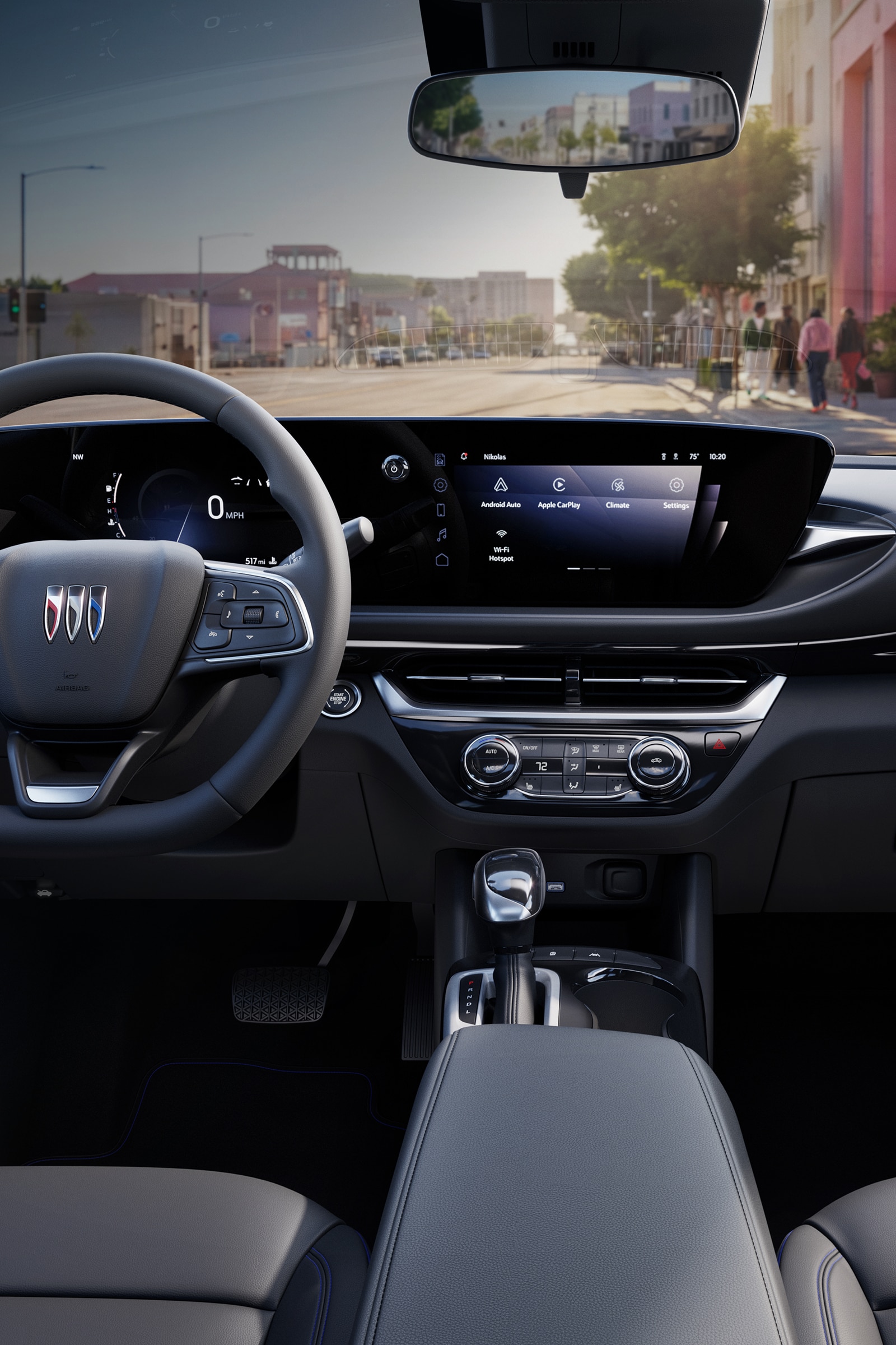An Interior View of a Buick Dashboard with a Large Digital Display Showing Navigation and Car Controls, with a Street View Through the Windshield