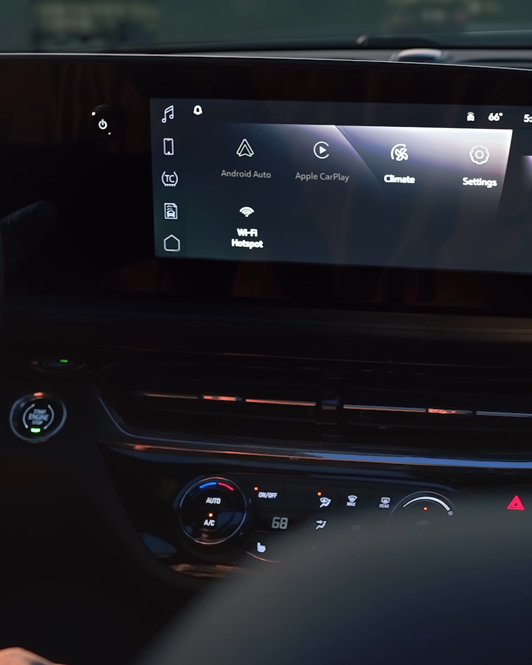 A Person's Hand Interacting with the Touchscreen Infotainment System On the Dashboard of a Buick Vehicle, with the Steering Wheel and Gauge Cluster Visible