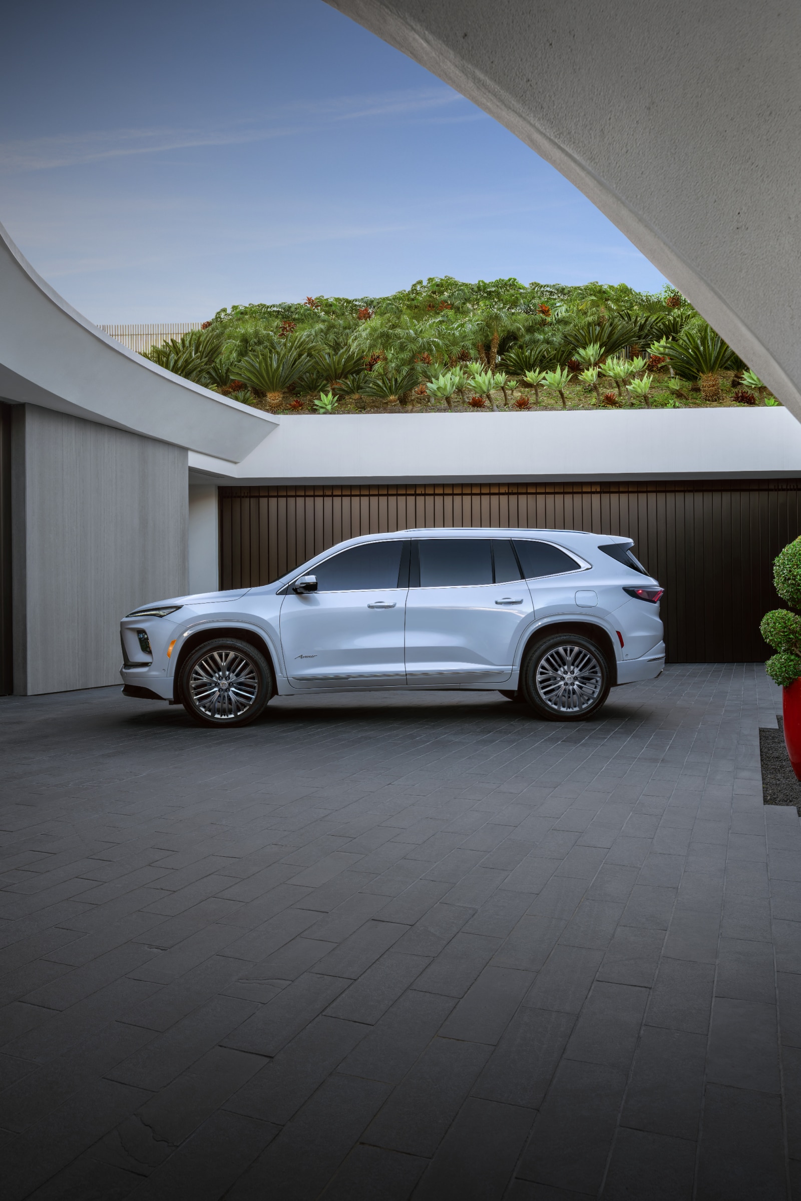 A Man And Woman Holding Hands Walking Past a White Buick Enclave SUV
