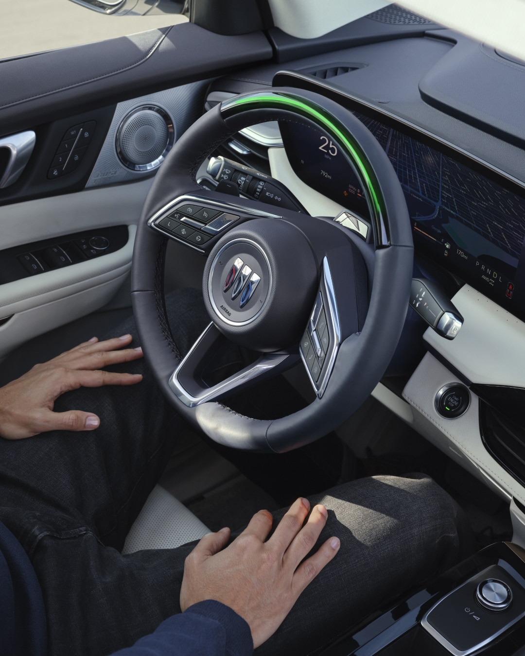 A Hand on the Dark Blue Buick Steering Wheel, Featuring the Buick Trishield Logo and Control Buttons