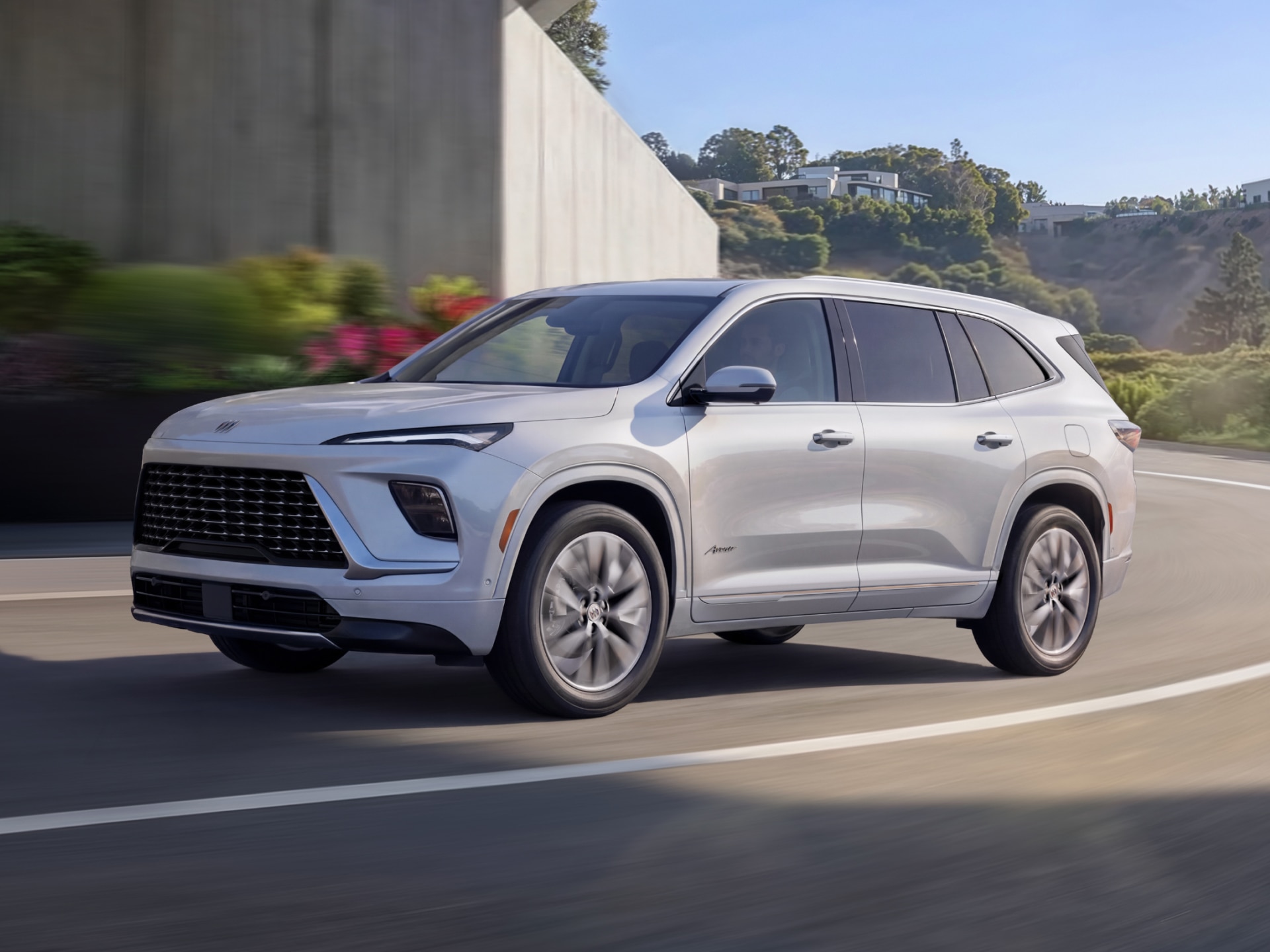 A White Buick Enclave Avenir SUV Driving on a Curved Road