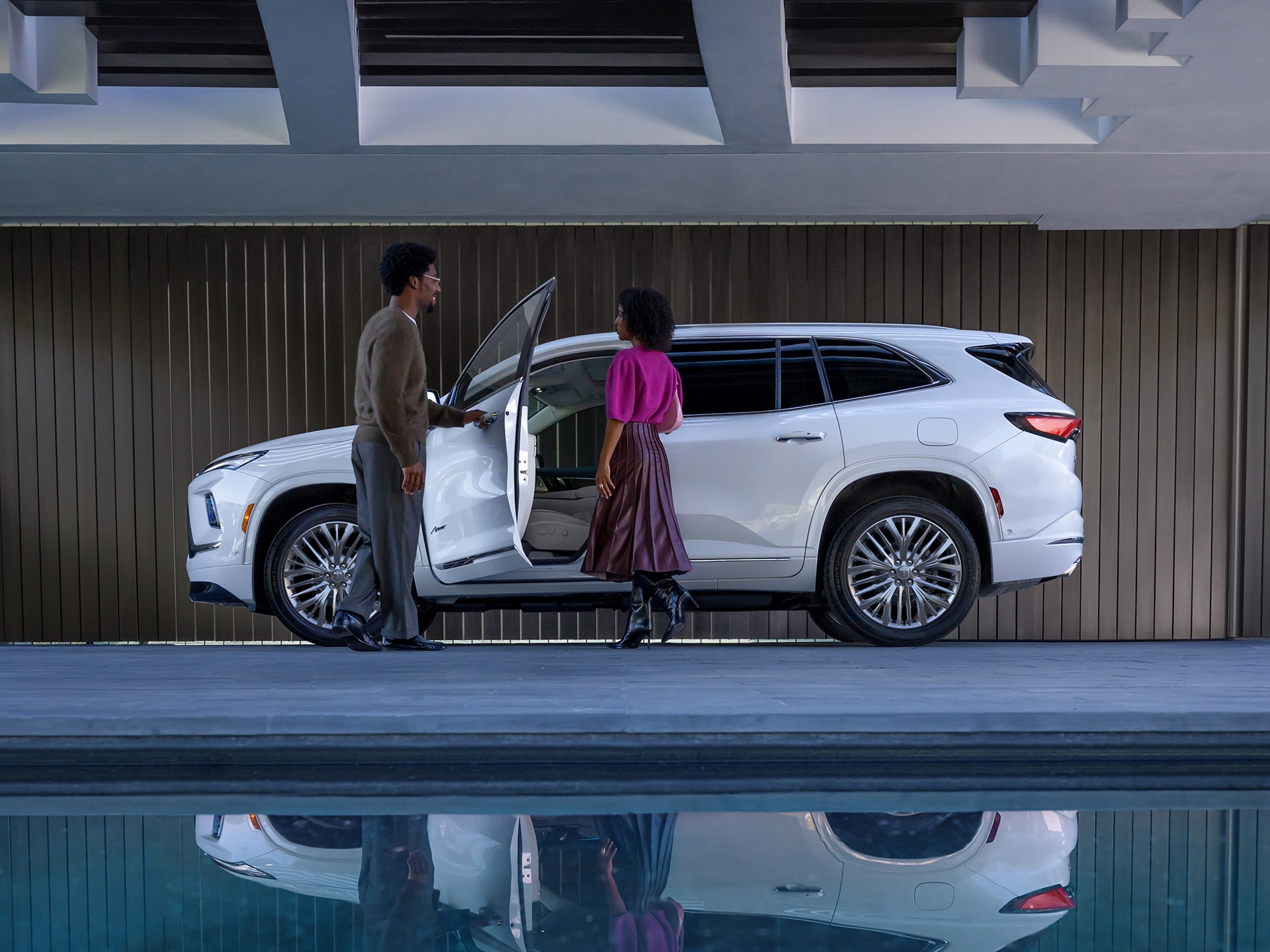 A White Buick Enclave SUV Parked on a Driveway in Front of a Modern Garage
