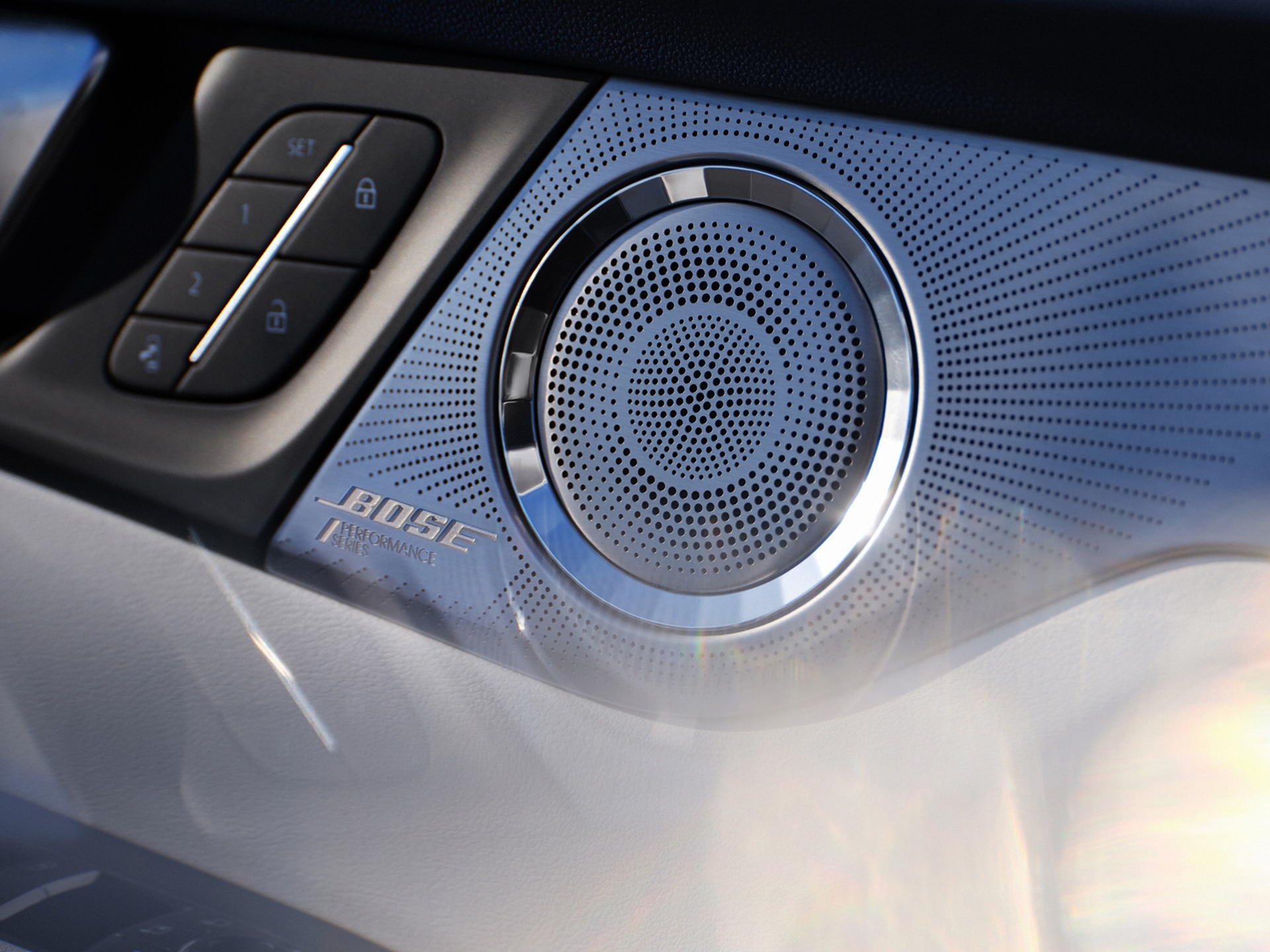 A Close-up of a Car Speaker Grille with a Silver BOSE Logo