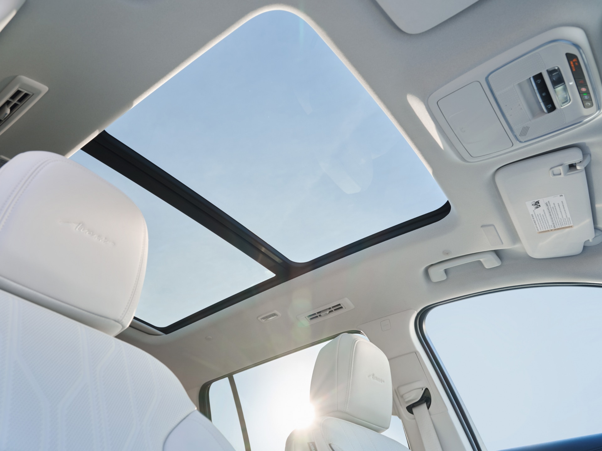 A Panoramic Sunroof of a Buick Vehicle Seen from the Interior with a Blue Sky