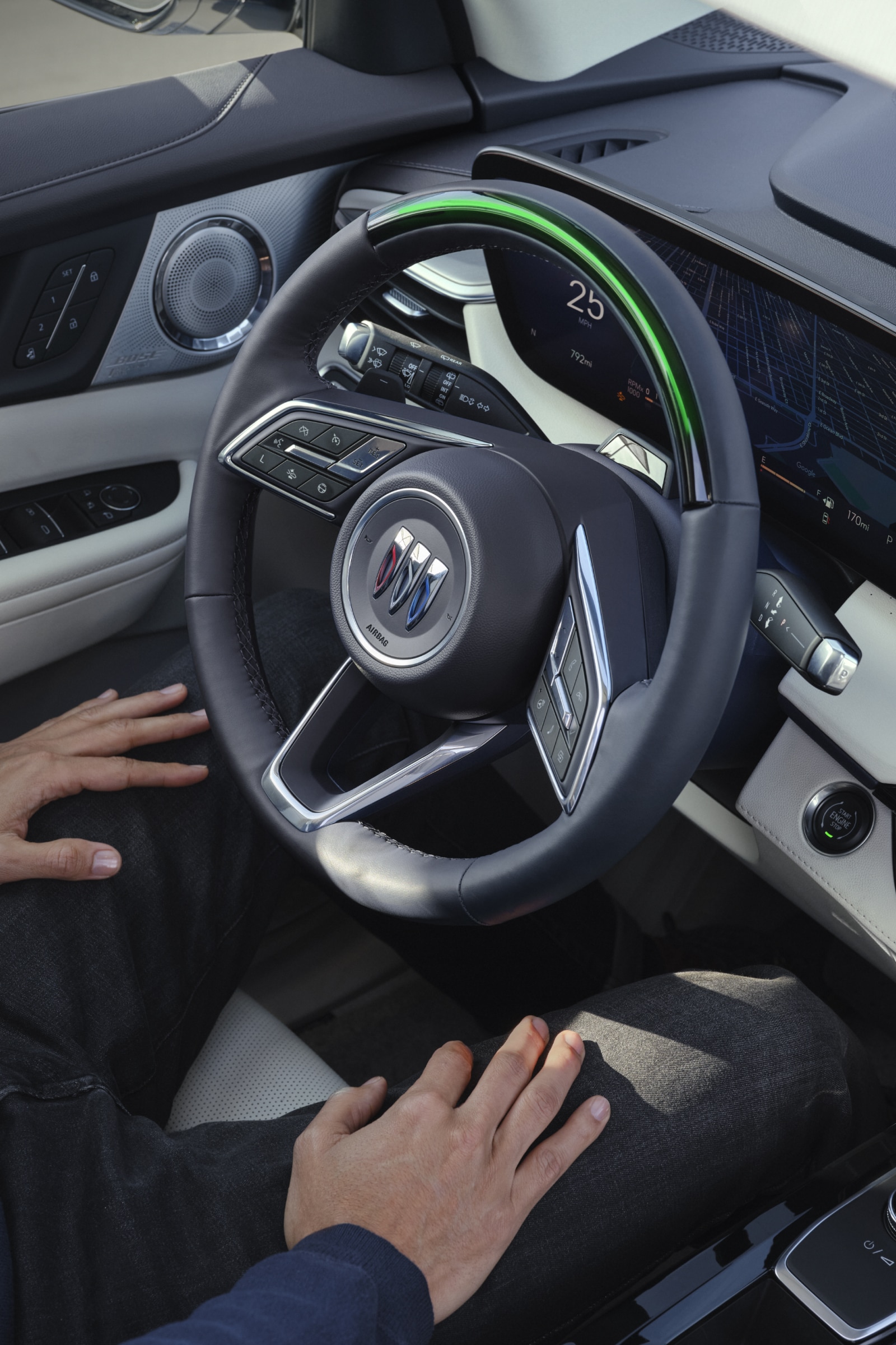 A Driver's Hands on their Lap Showing the Buick Steering Wheel With a Digital Dashboard Display