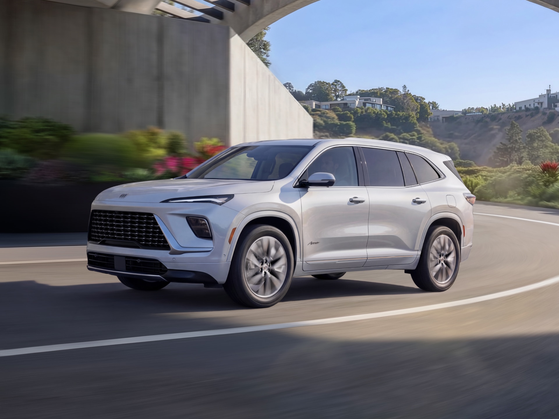 A White Buick Enclave Avenir SUV Driving on a Curved Road