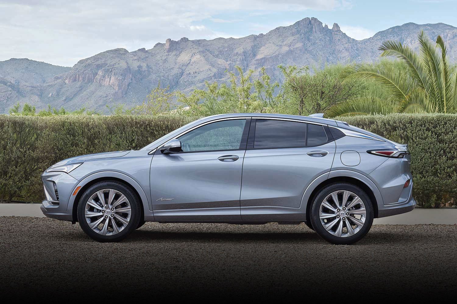 A Gray Buick Envista Avenir SUV Parked on a Gravel Driveway with Mountains in the Background