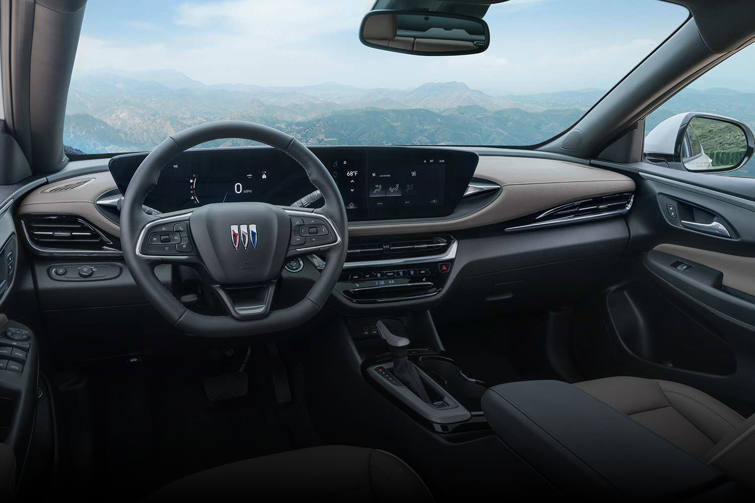 A Gray Buick Envista Avenir SUV Parked on a Gravel Driveway with Mountains in the Background