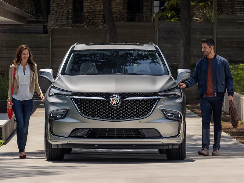 A Person Holding a Phone Walks In Front of the Impressive Front End Design of Enclave Avenir