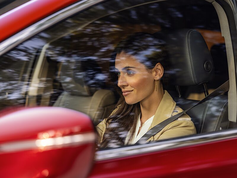 A Woman Driving Her Buick Enclave While Smiling