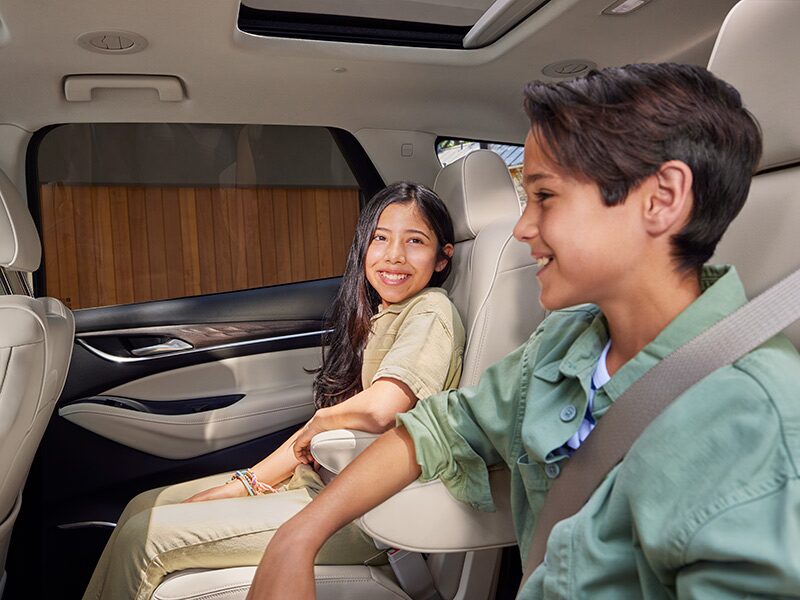 Two Small Kids Sitting in the Back of the Buick Enclave