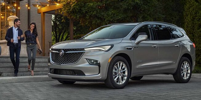 A Couple Walking Toward Their Parked Buick Enclave