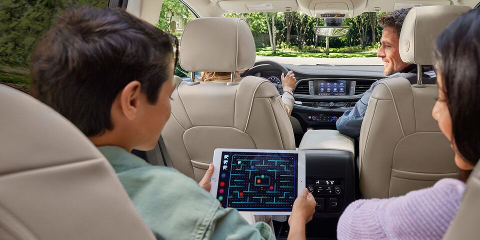 A Boy Shares His Tablet with His Sister While Enjoying a Ride in Their Families Enclave