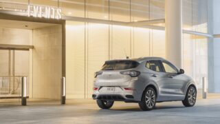 A Happy Couple Walking Out of a Building Towards Their Buick Encore GX Avenir