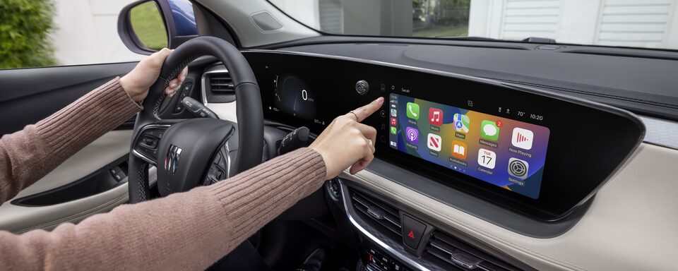 A Woman Adjusting the Settings of Her Infotainment System on the Buick Encore GX