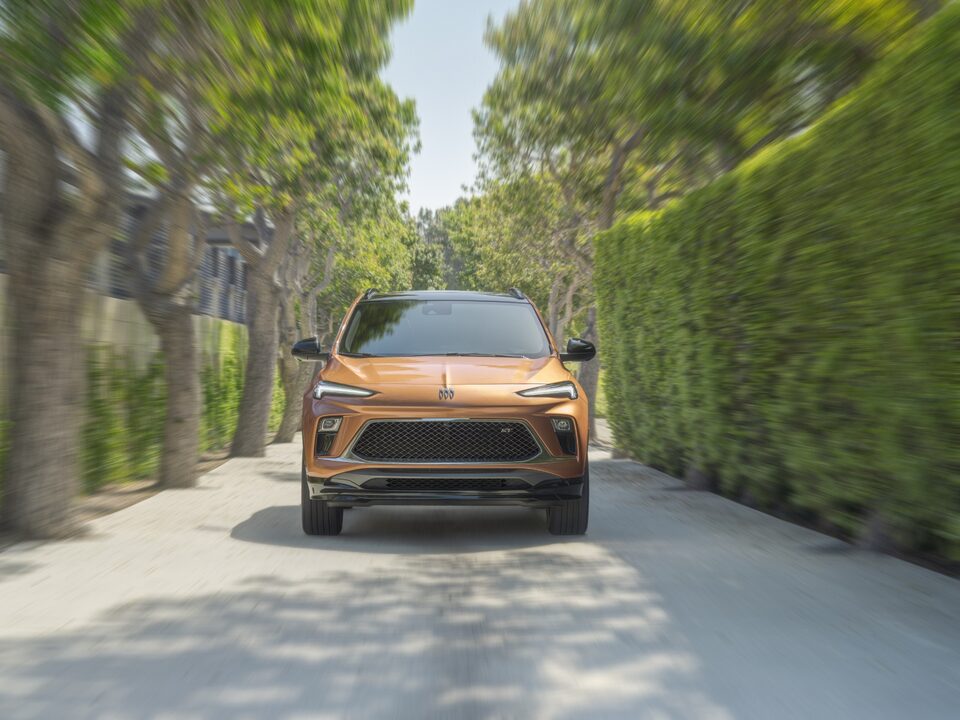 Head-On View Of The 2024 Buick Encore GX ST Driving Down Tree-Lined Road