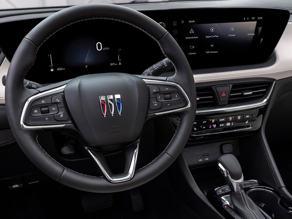 A Woman in the Driver’s Seat of the Buick Encore Gx Utilizing Apple Carplay